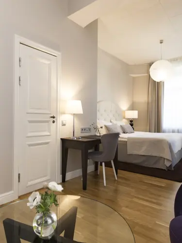 Hotellrum med dubbelsäng, fönster och skrivbord