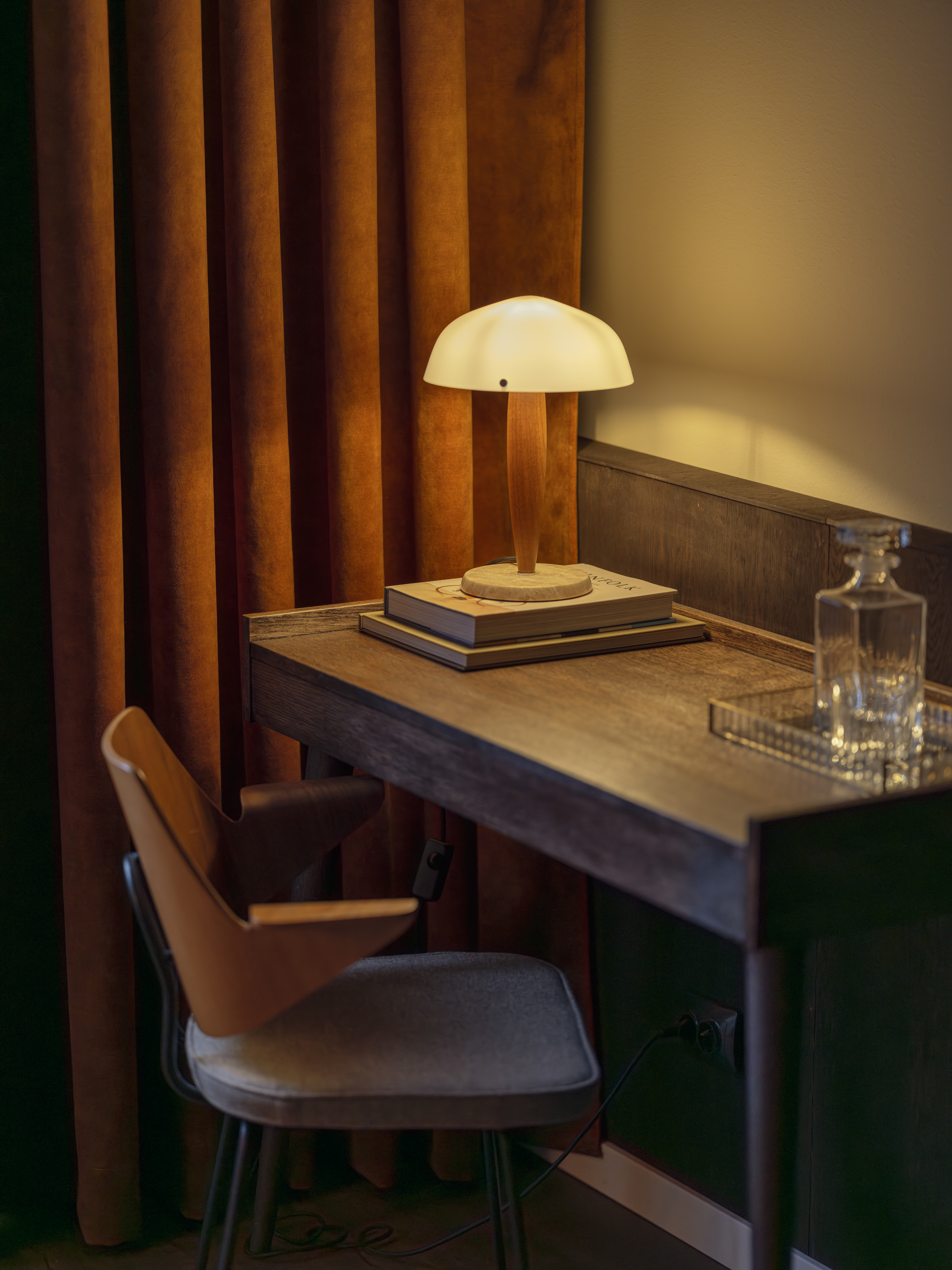 Ljust hotellrum med säng, tv och skrivbord