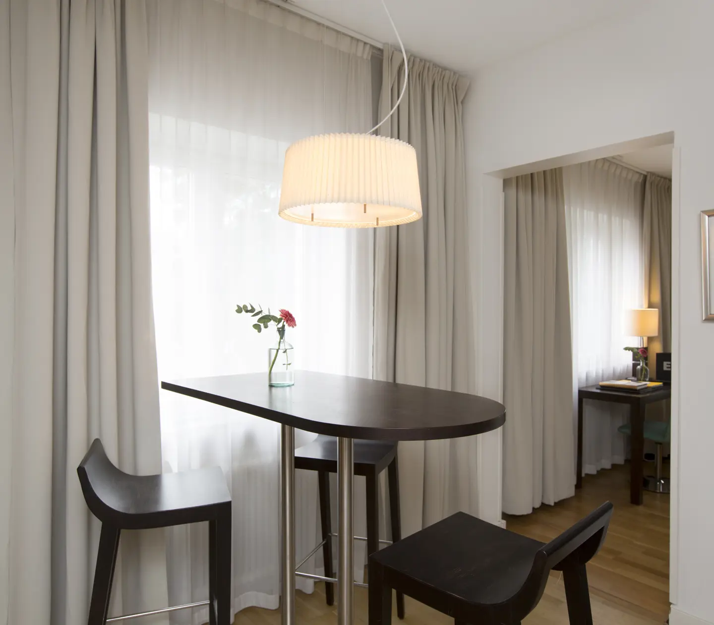 Bright apartment suite with bar table, desk and window
