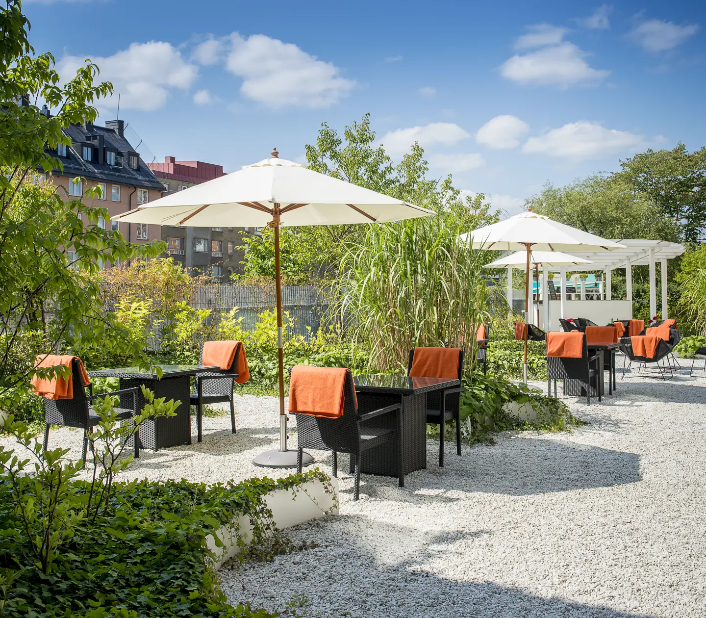 Outdoor seating with greenery, dining groups and parasols