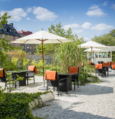 Outdoor seating with greenery, dining groups and parasols