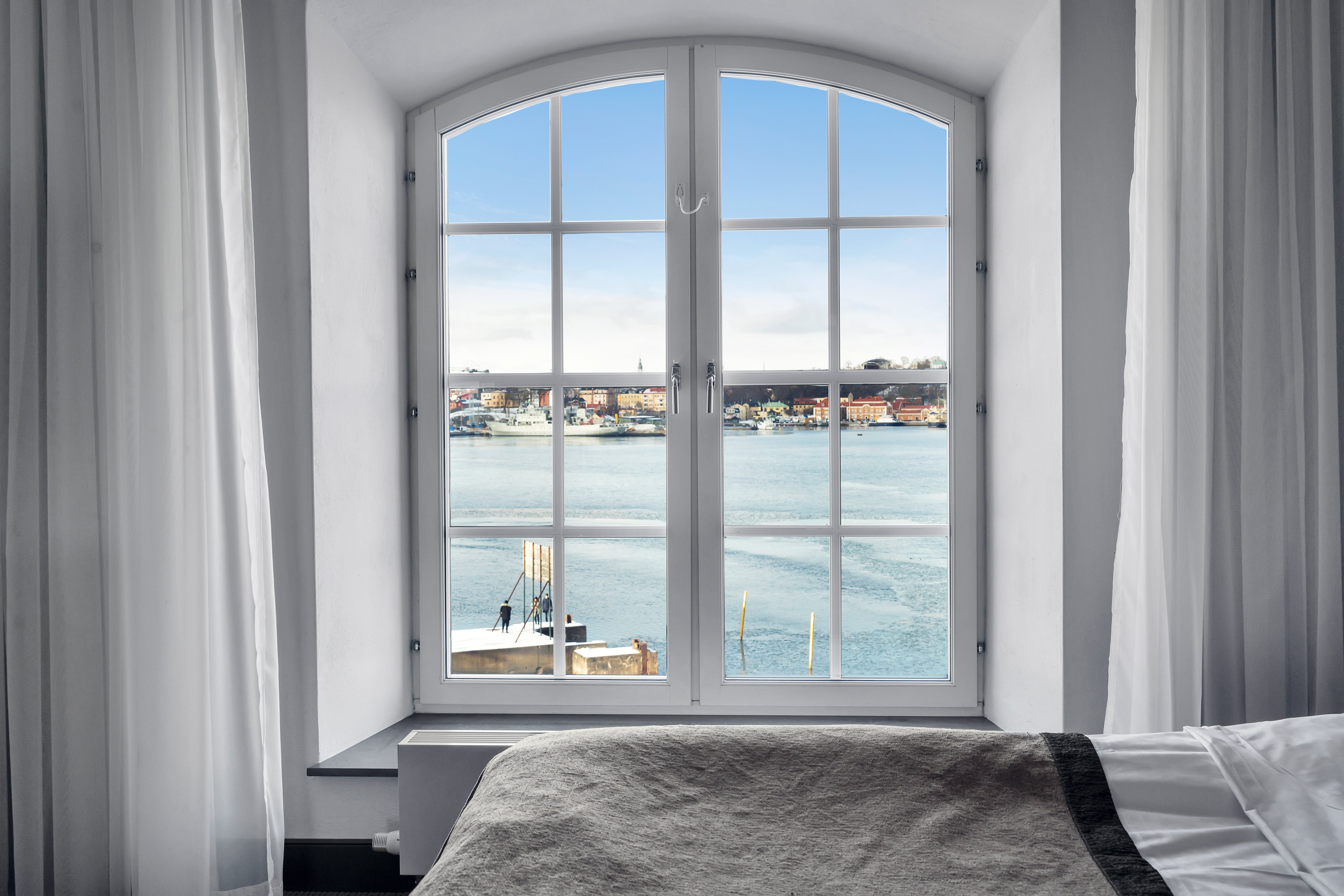 Ljust hotellrum med fönster med utsikt över havet och Djurgården
