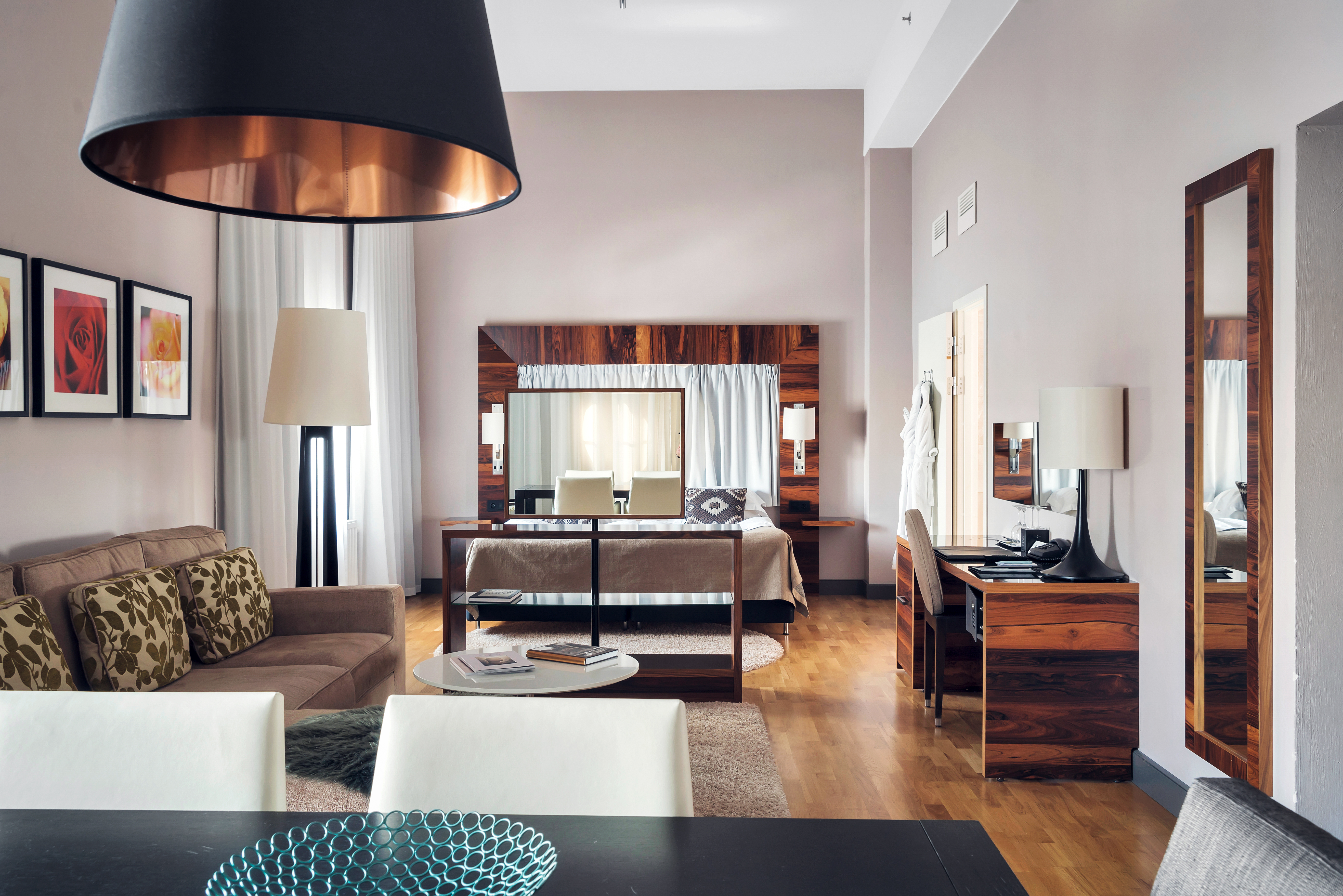 Bright suite with high ceiling, sofa group and desk