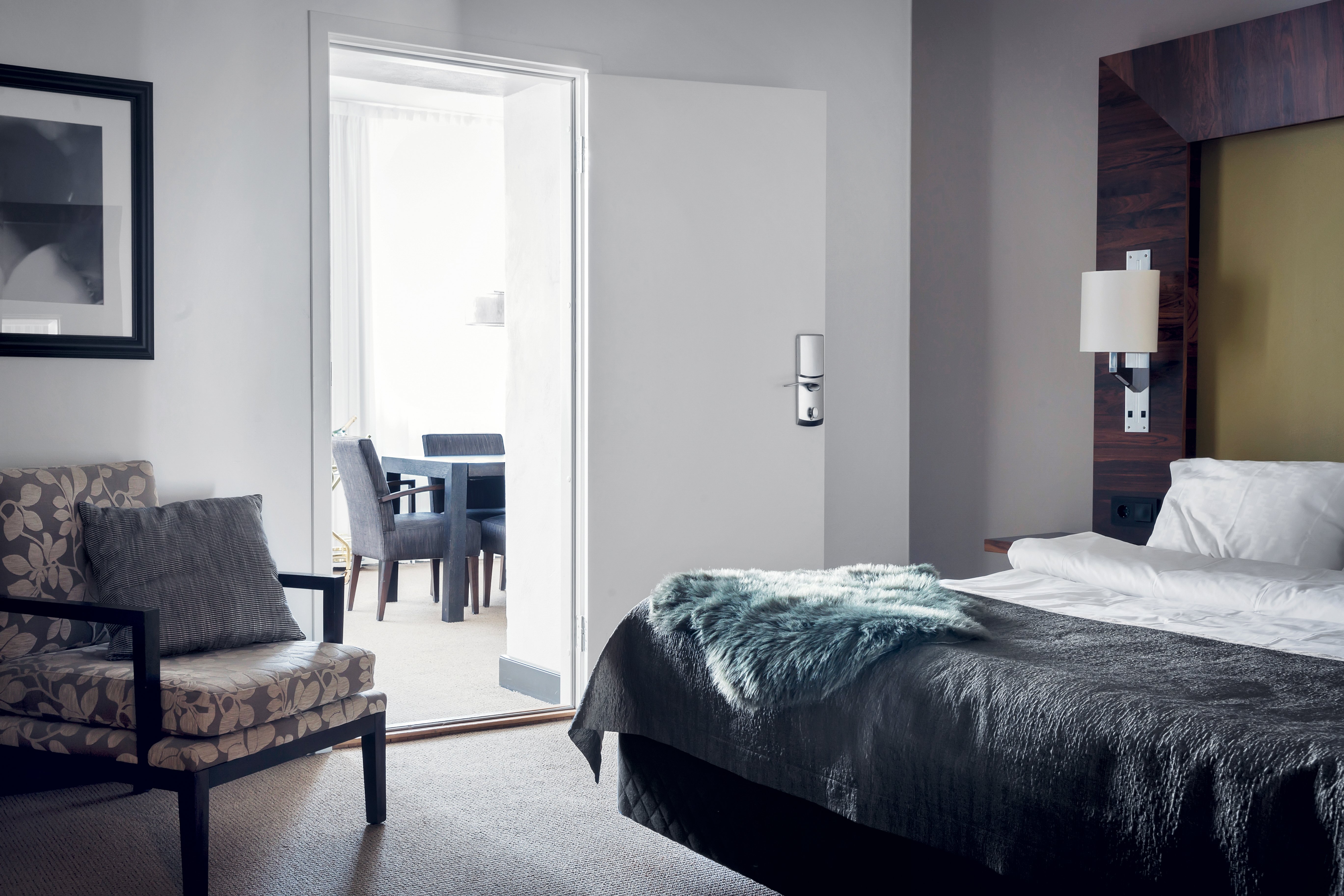 Bright suite with bed, armchair and dining group