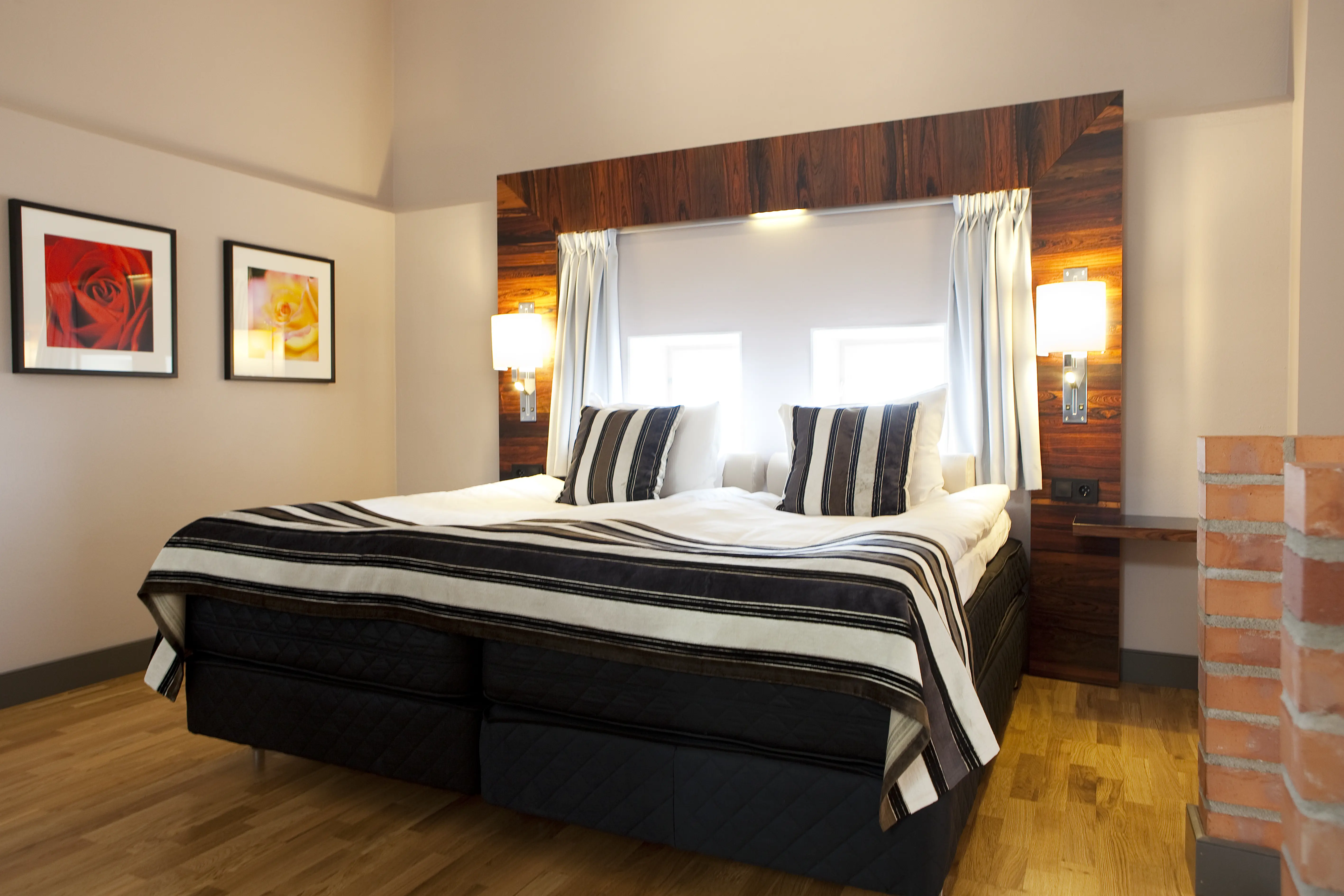 Bright suite with high ceiling, bed and paintings