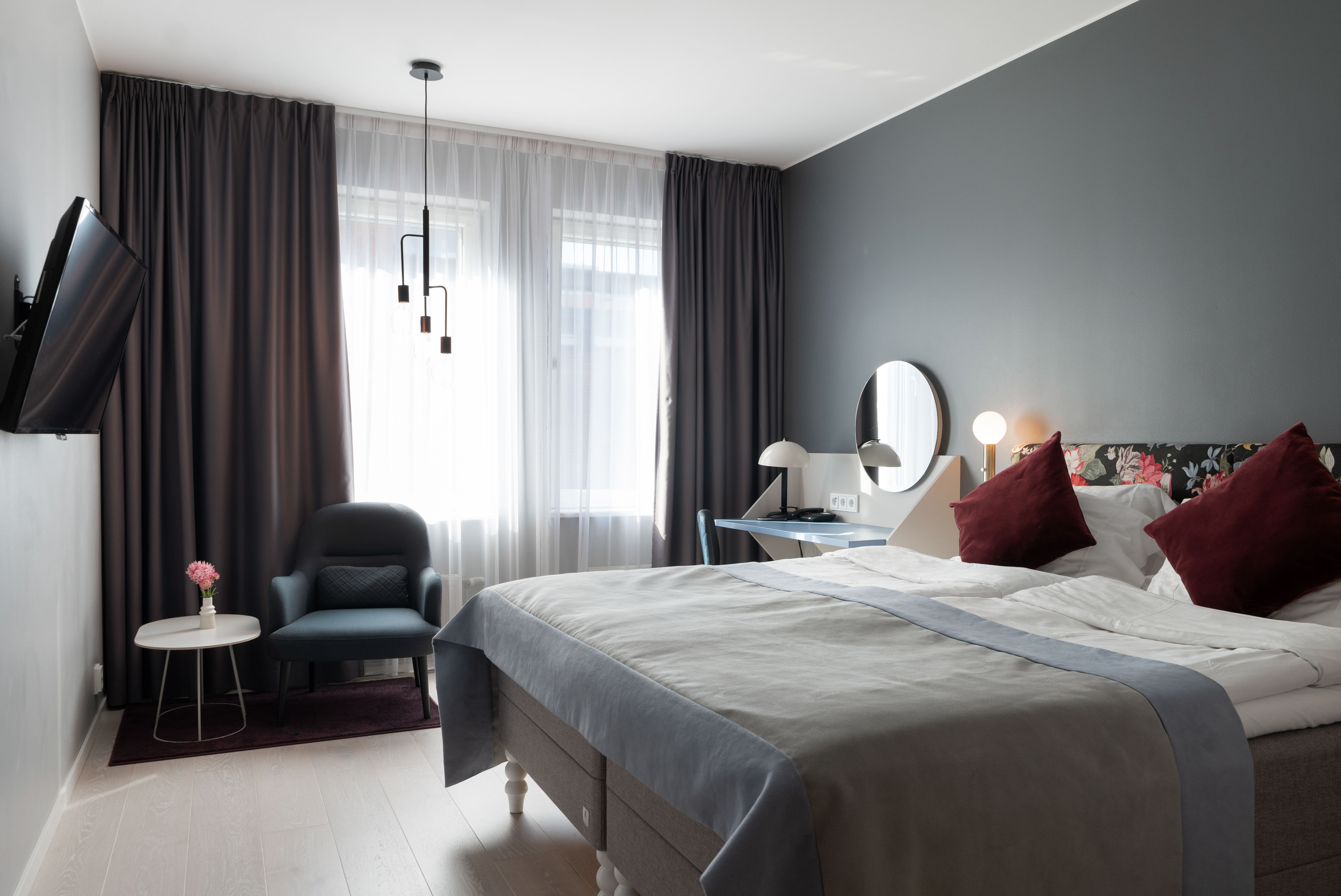 Double bed, armchair and TV in hotel room