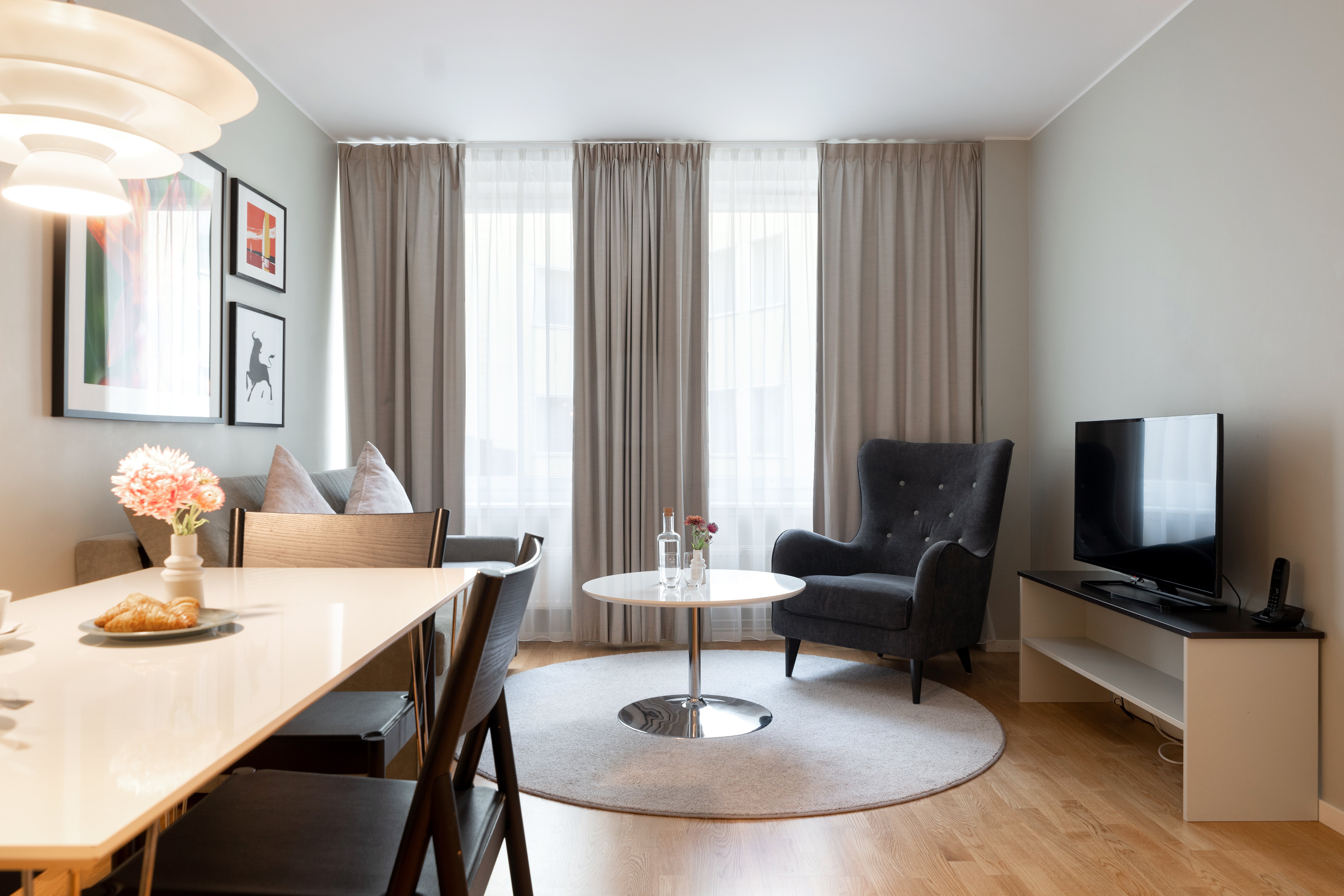 Table with chairs and lounge area with sofa and TV