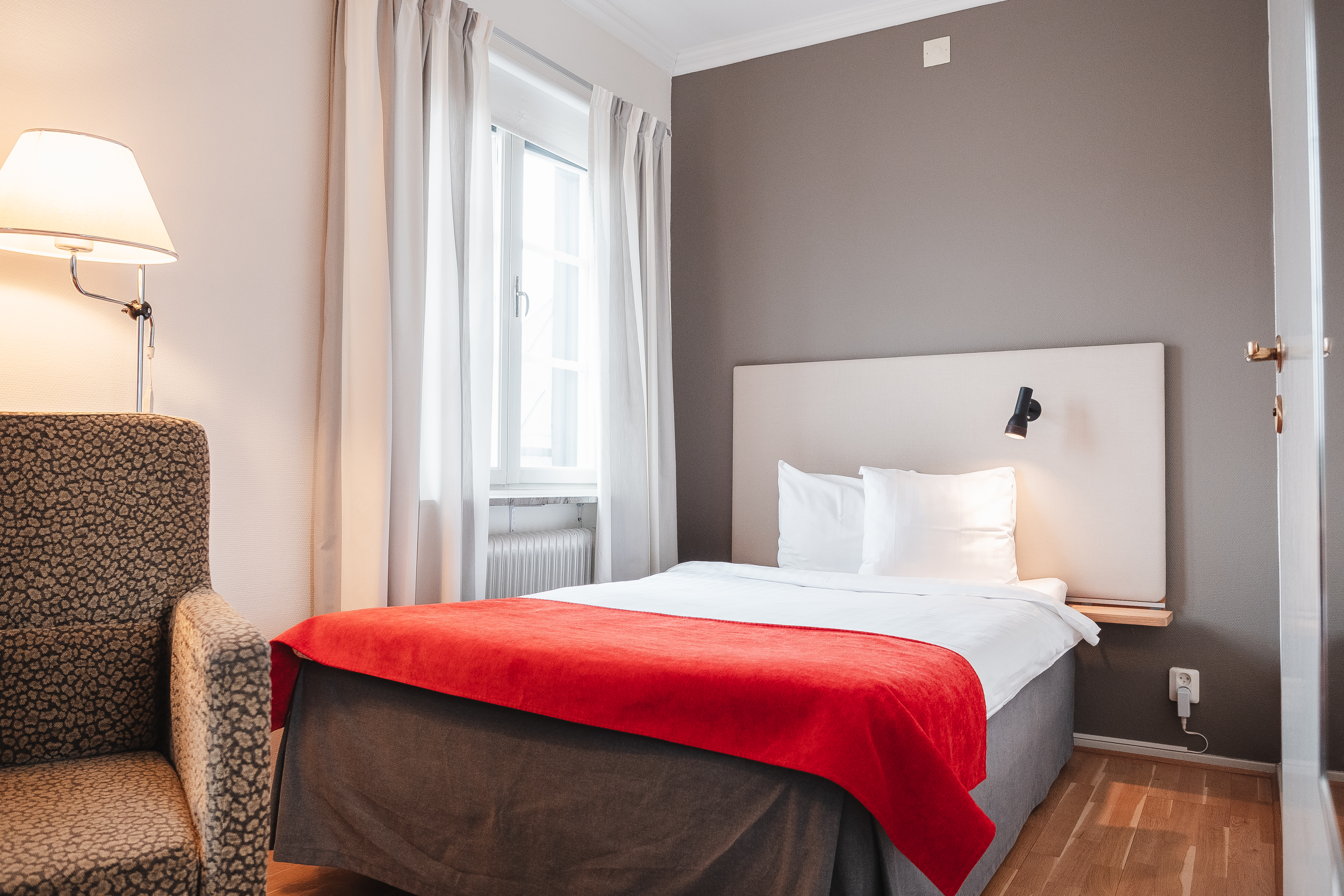 Cozy hotel room with bed, armchair and window