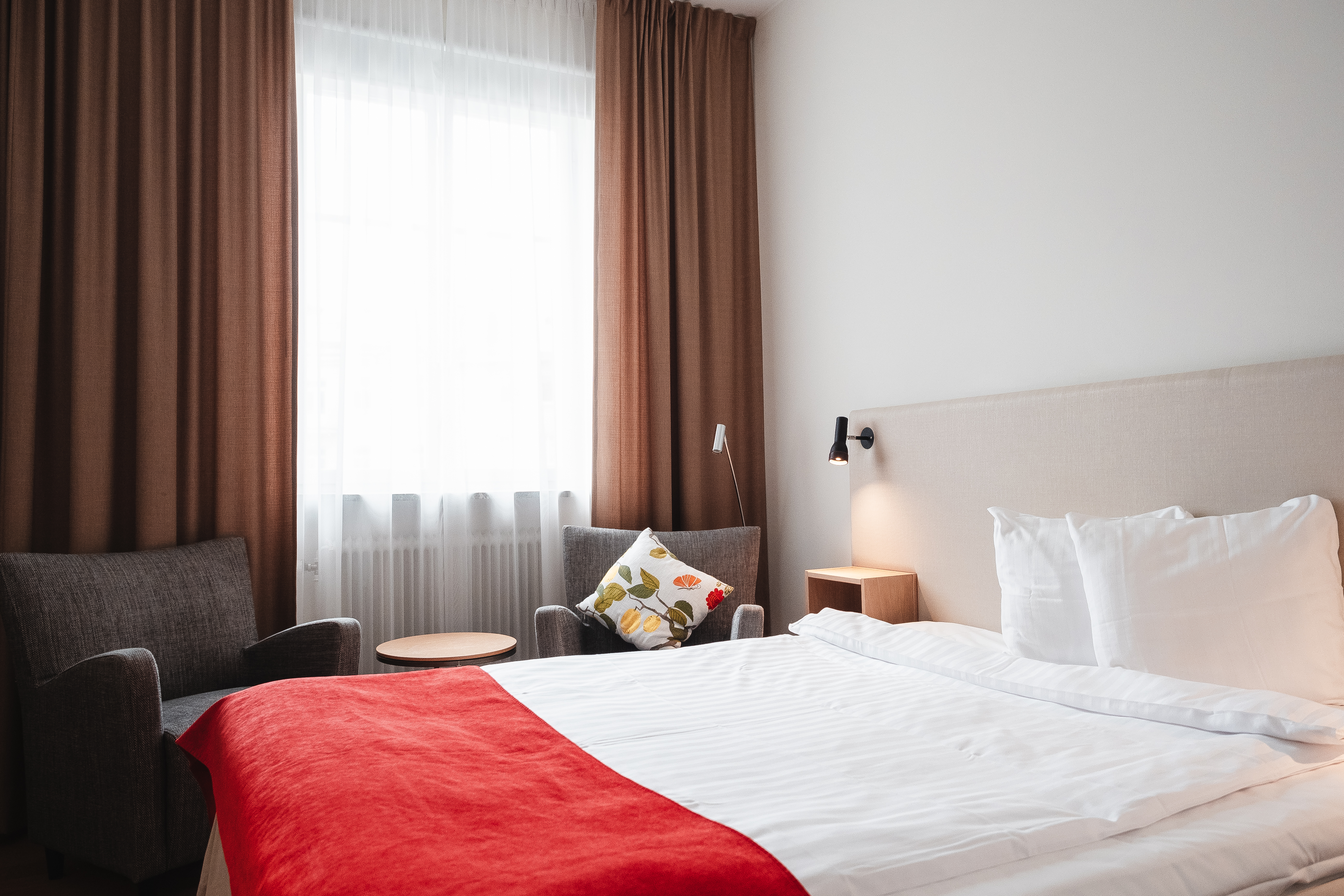 Cozy hotel room with bed, armchairs and window