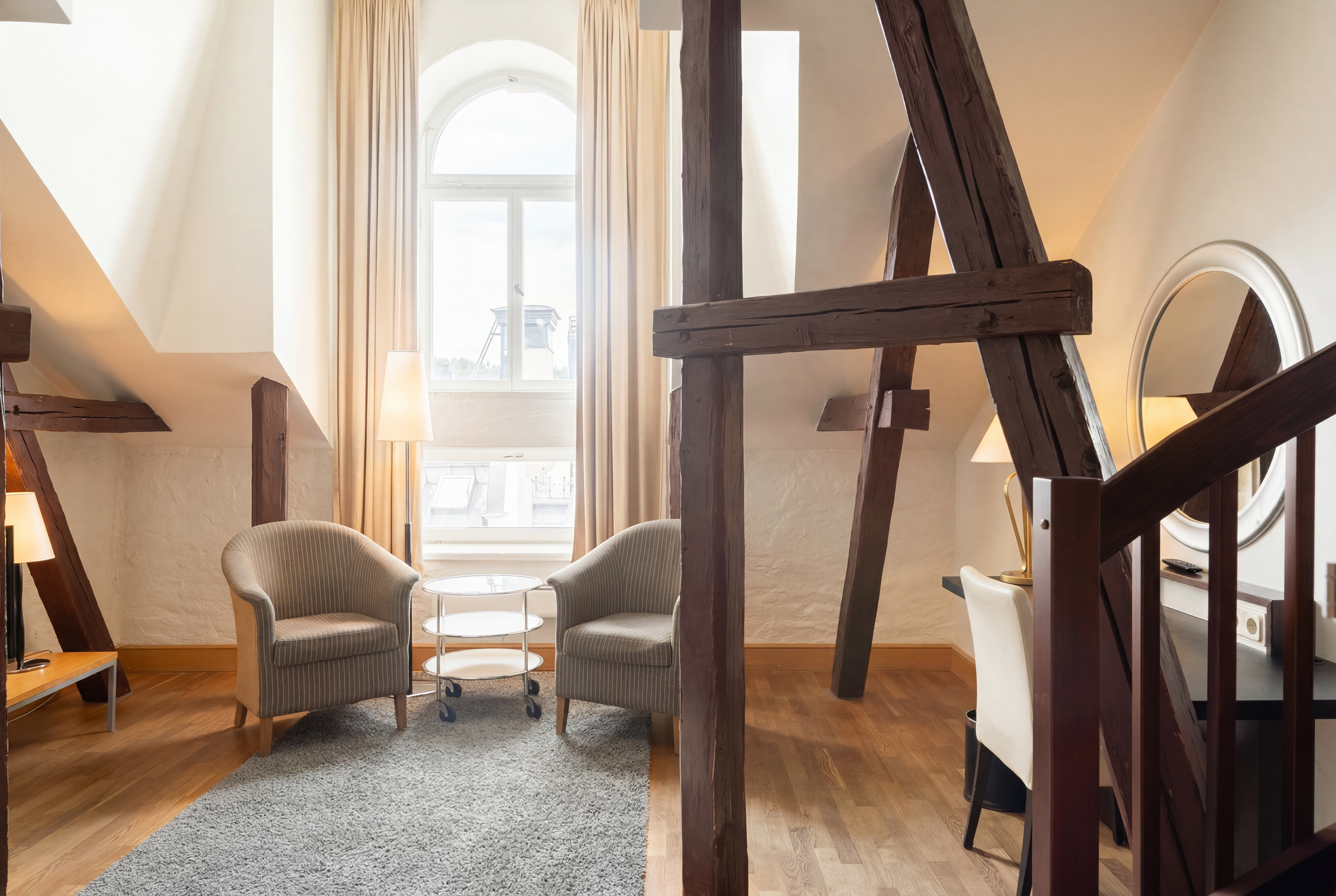 Ett ljust rum med ett stort fönster och två fåtöljer