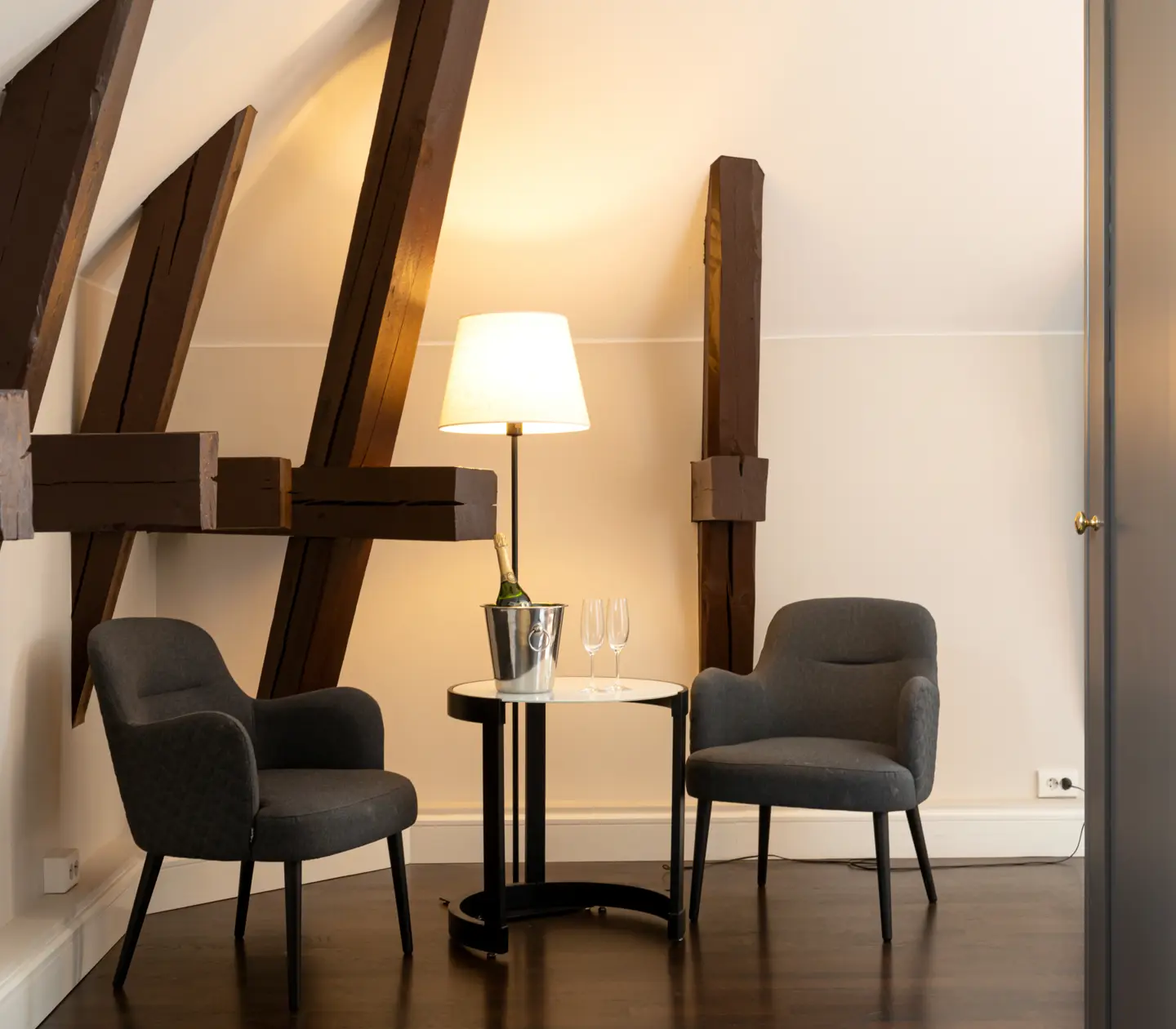 Bright suite with two armchairs, wooden beams and wardrobe