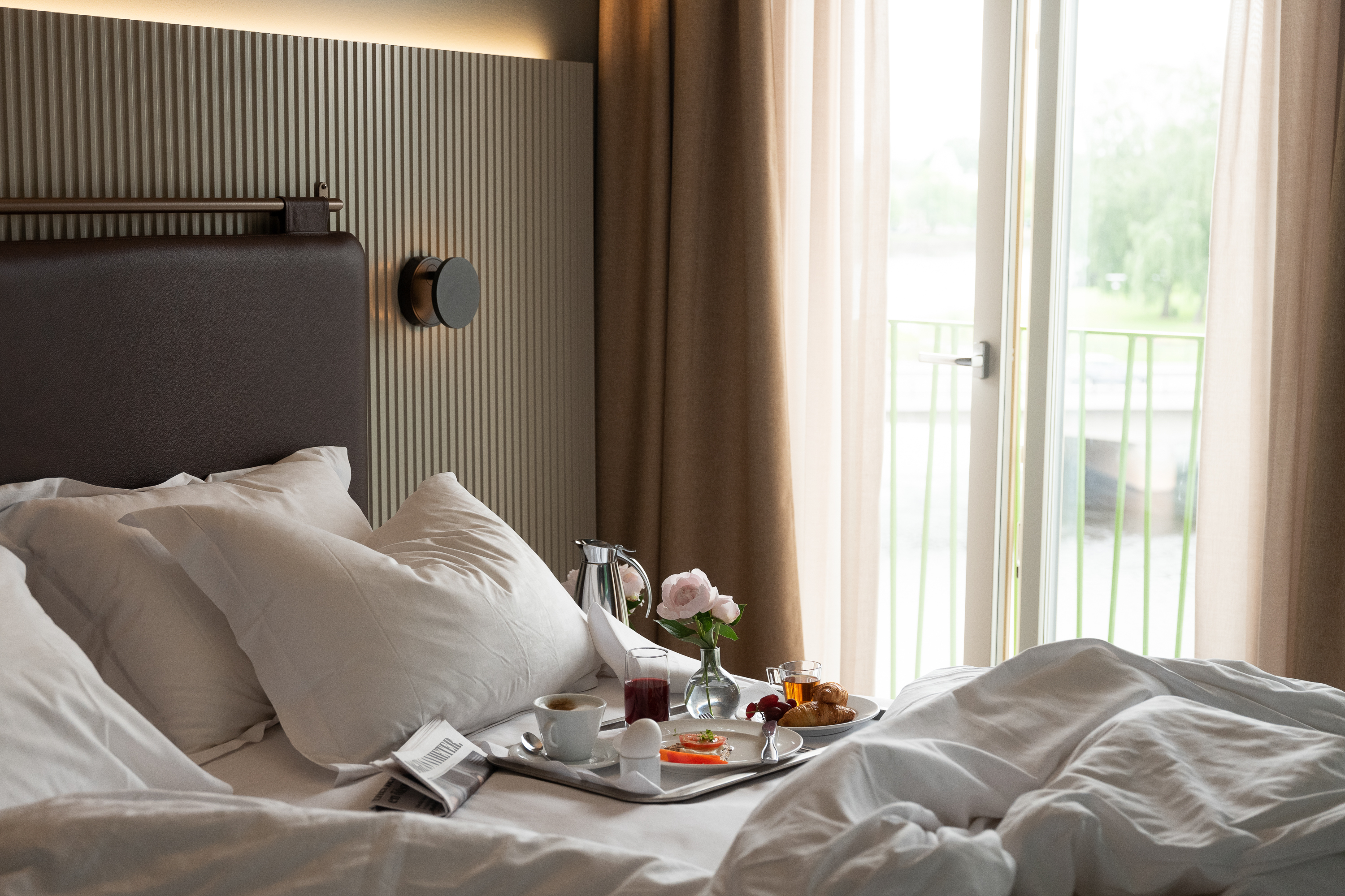 Hotellrum med frukostbricka och öppen balkongdörr