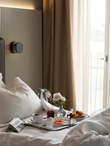 Hotellrum med frukostbricka och öppen balkongdörr