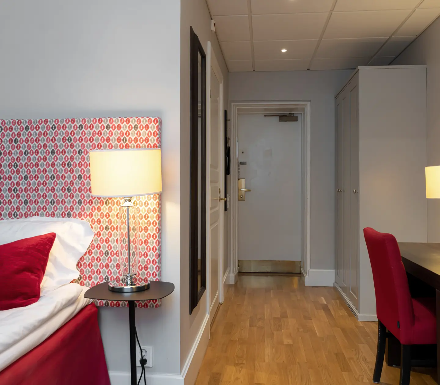 Hotellrum med säng, skrivbord och garderob