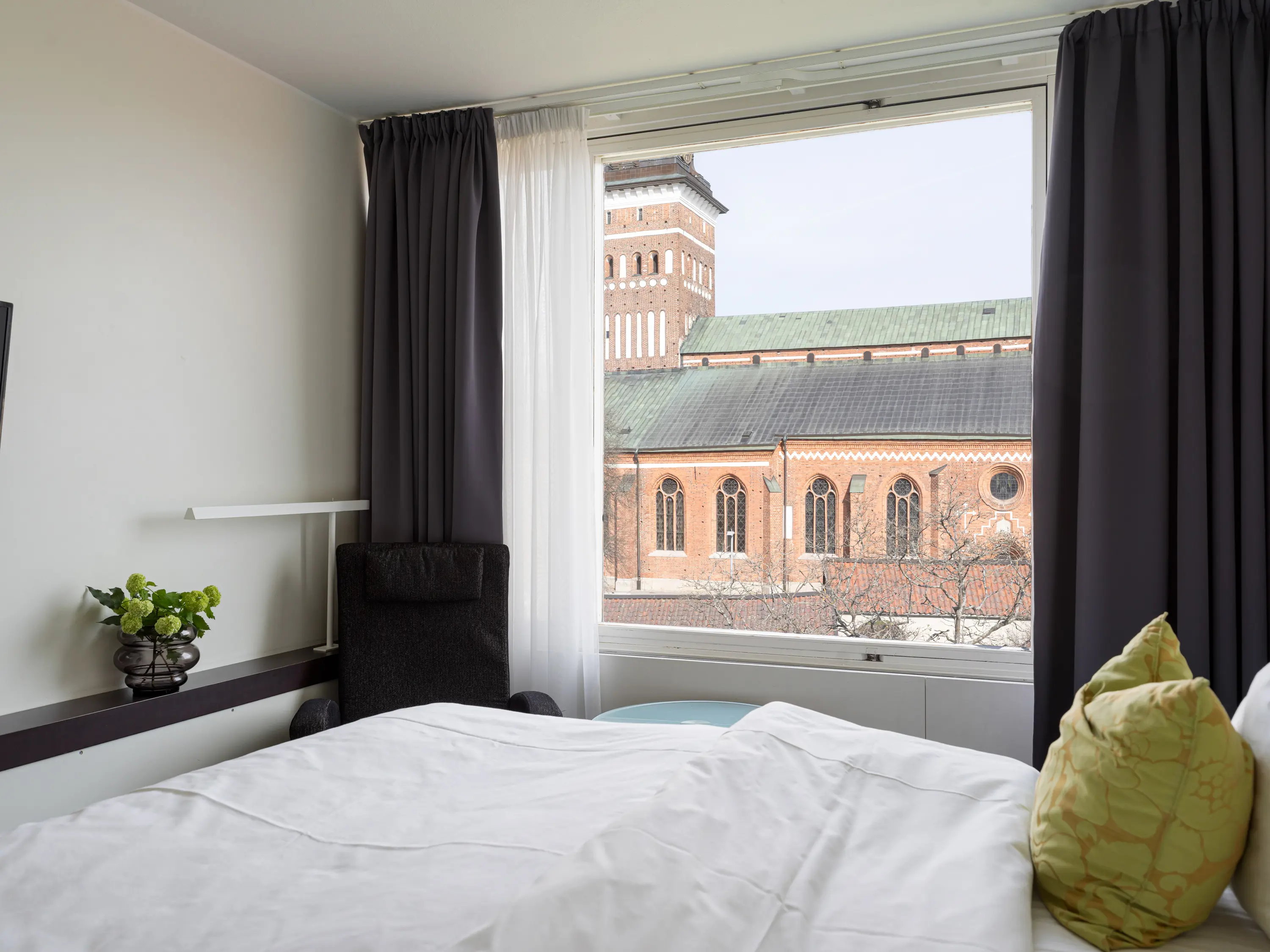 Mysigt hotellrum med säng, fåtöljer och skrivbord