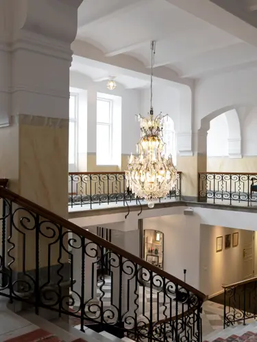 Pampig hotellmiljö med trappor och kristallkronor
