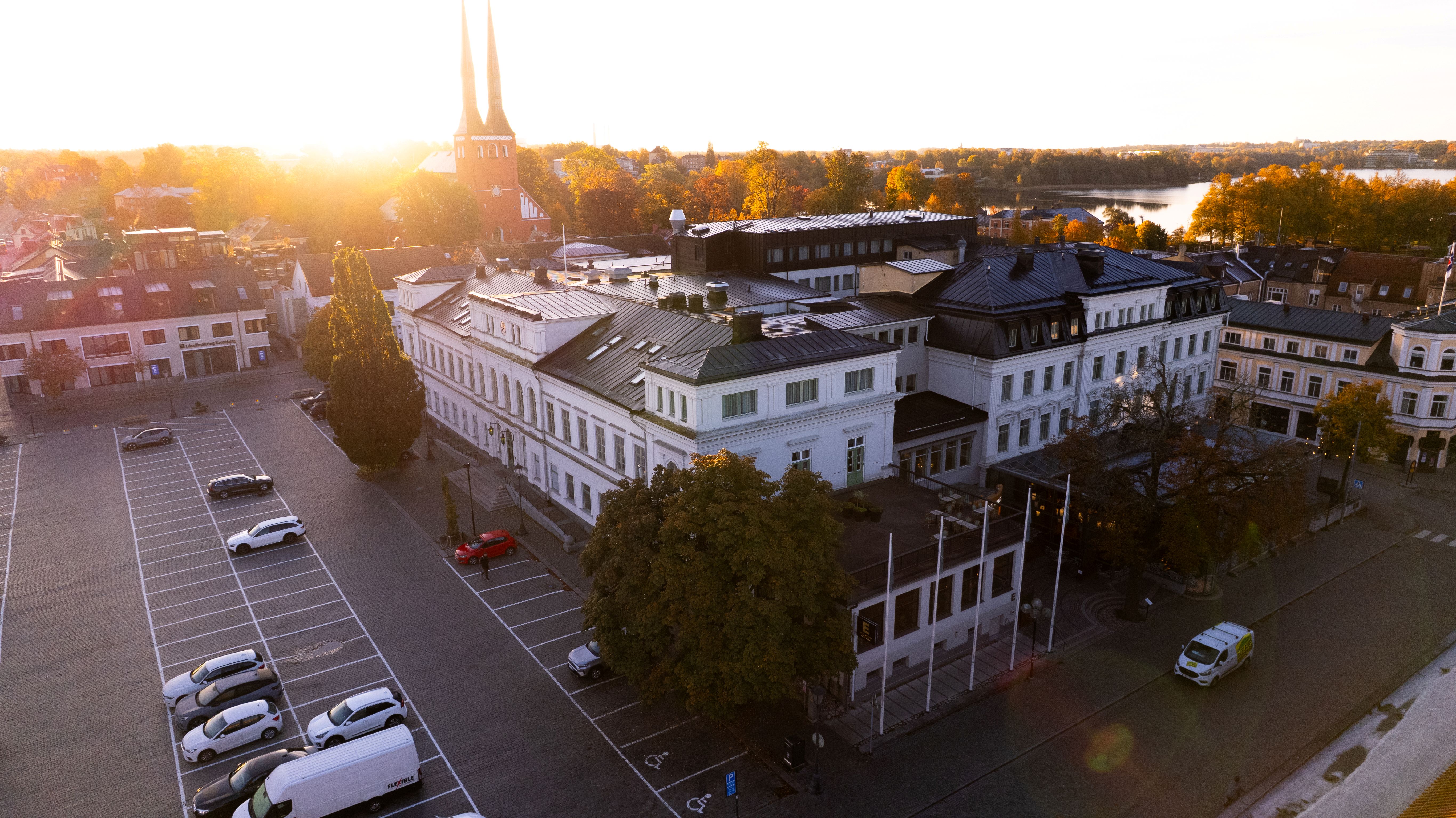 Solnedgång över vit byggnad vid vatten