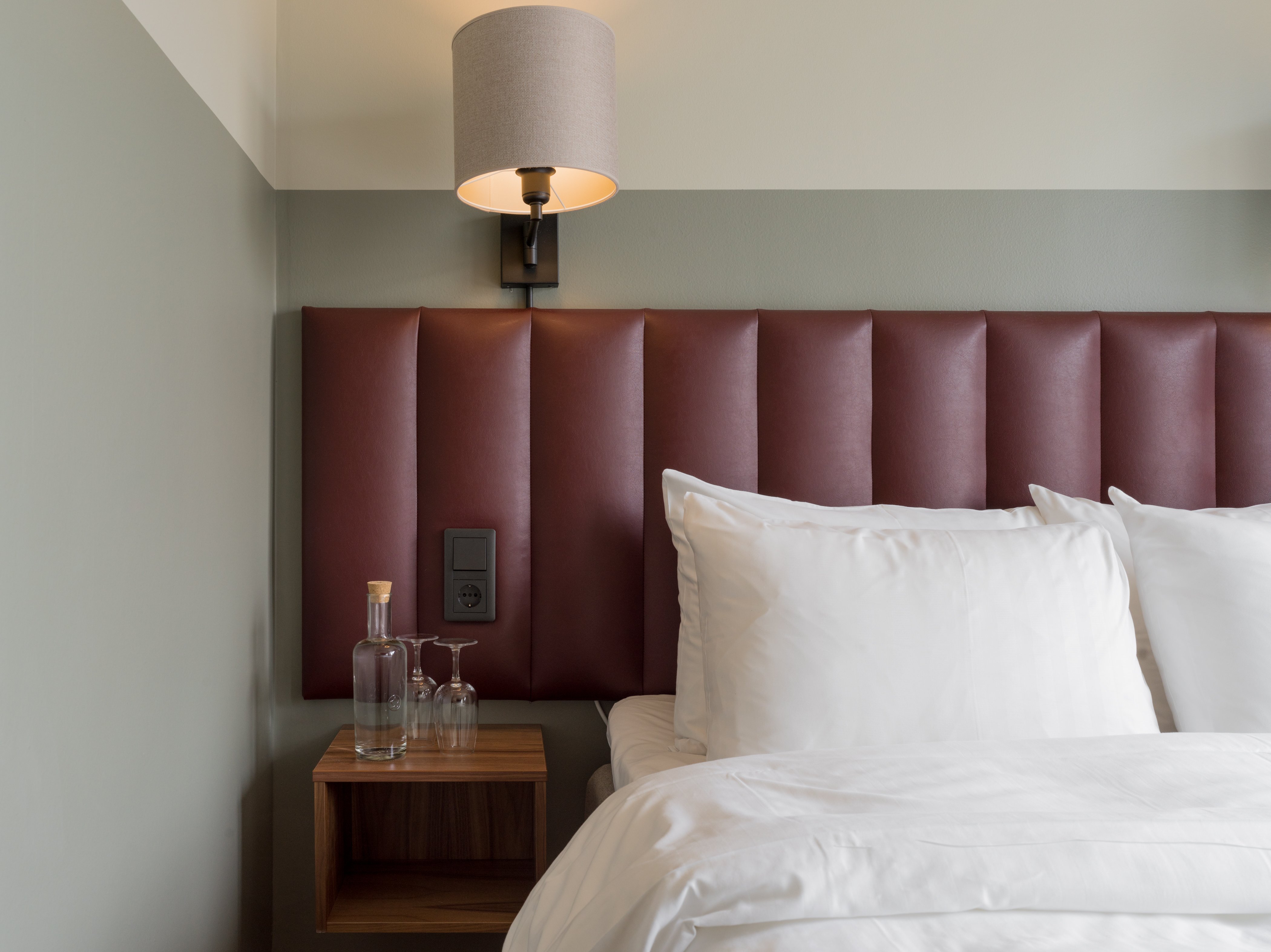 Close-up of double bed with red headboard