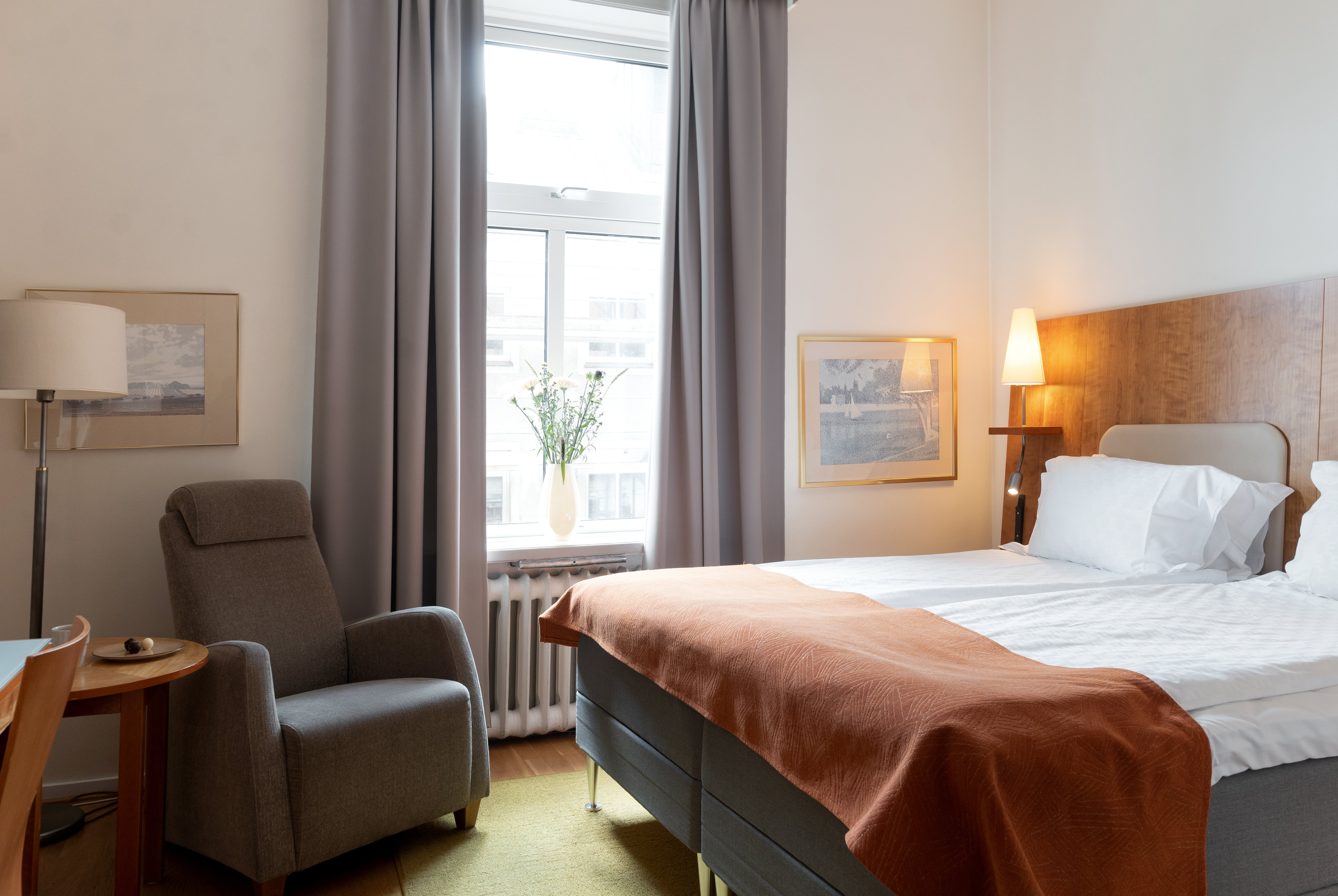 Cozy hotel room with double bed, armchair and window