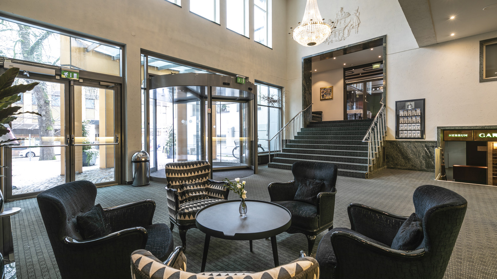 Hotel lobby with armchairs, large glass windows and stairs