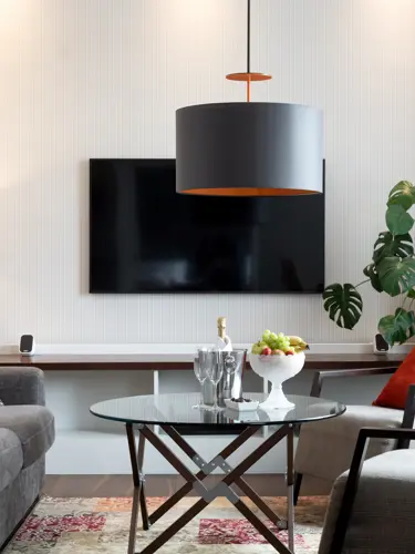 Hotel suite with lounge furniture, TV and flowering plants