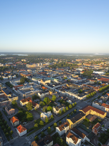 Drönarbild över Växjö med hus i förgrunden och hav i bakgrunden