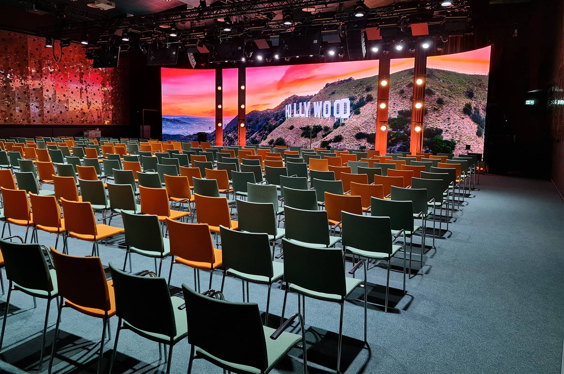 A conference hall with a large screen behind the stage