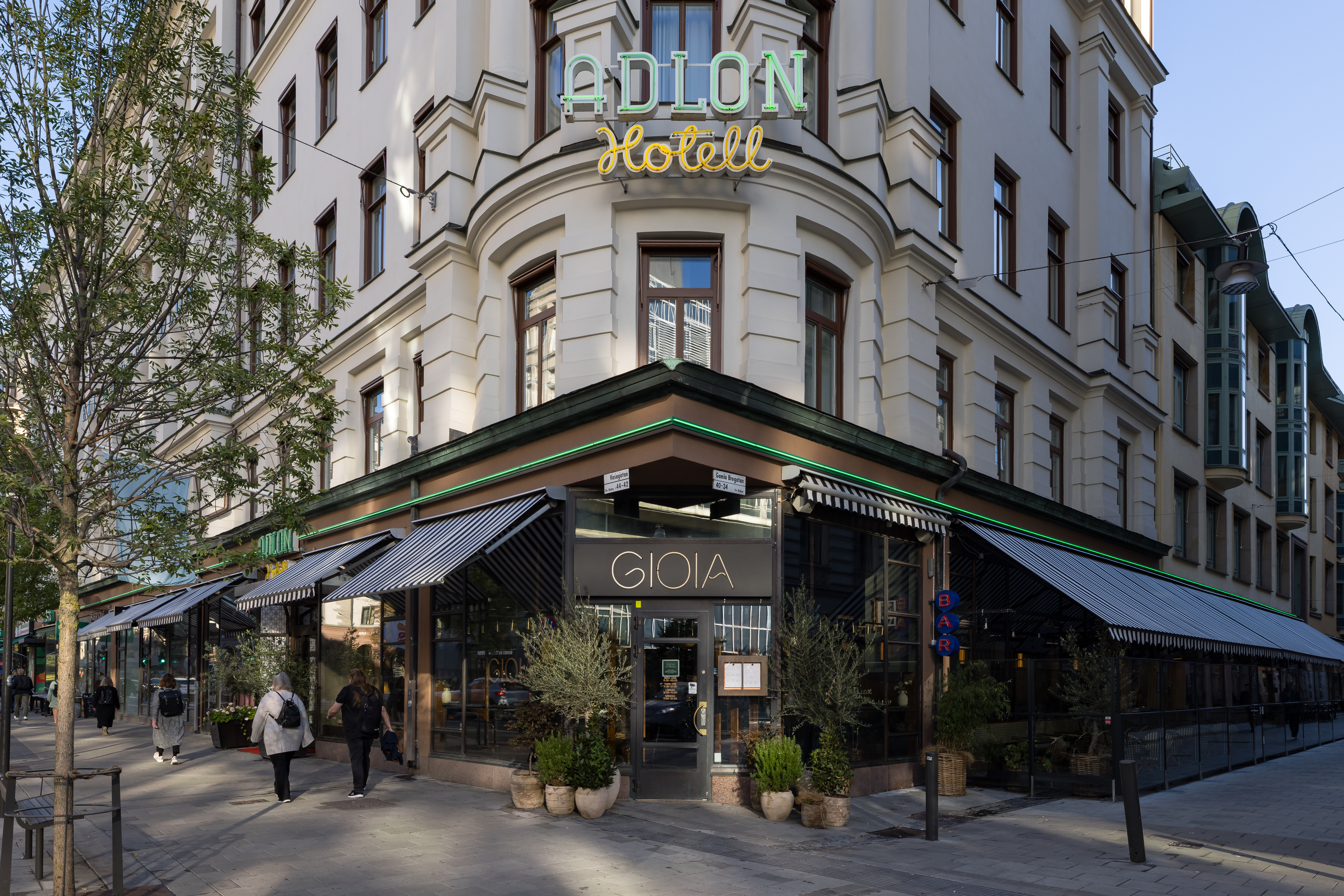 Fyra personer skålar med vinglas runt ett bord fyllt med te och desserter i en restaurangmiljö