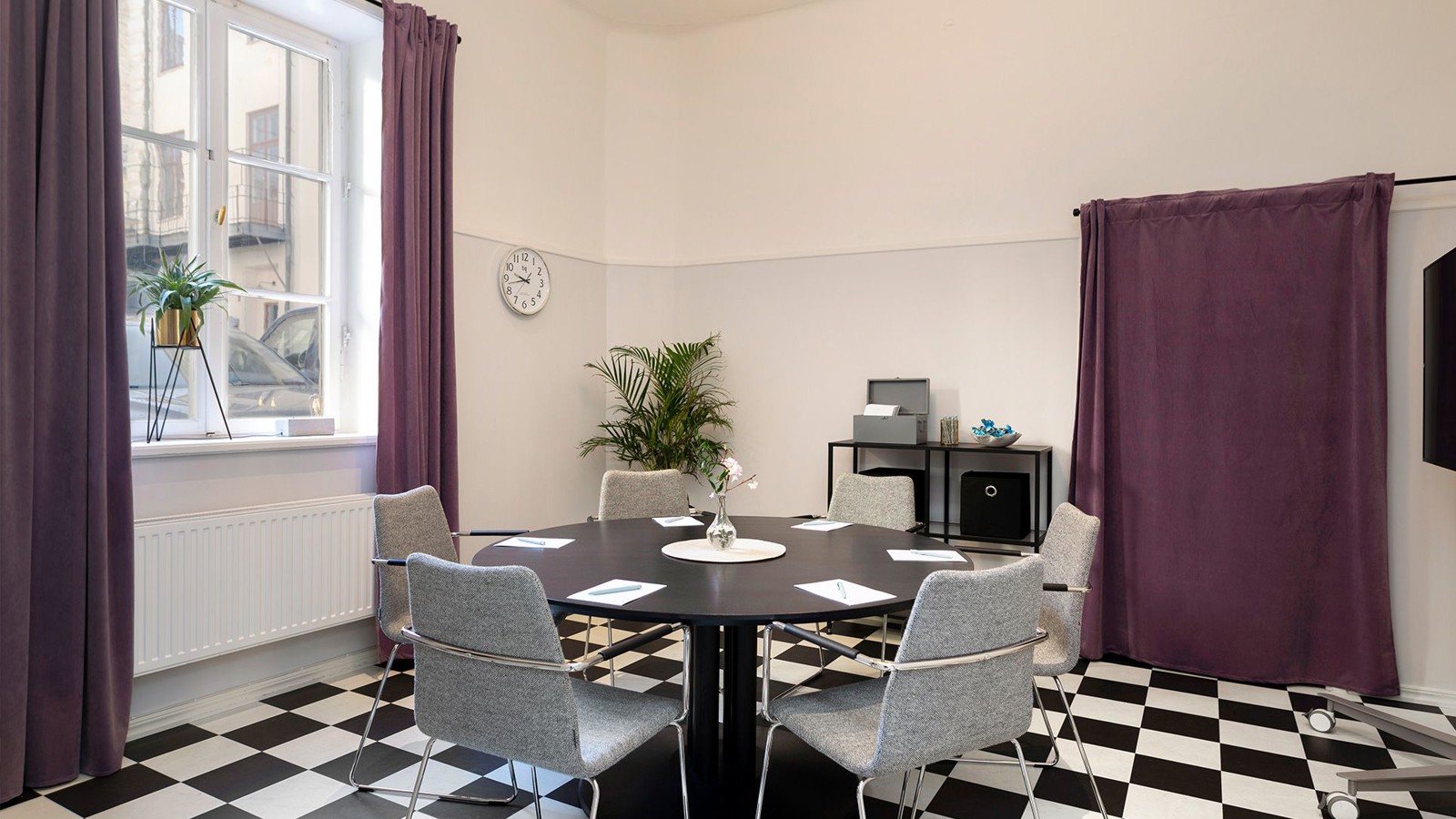 Conference room with checkerboard floor, round table and large window