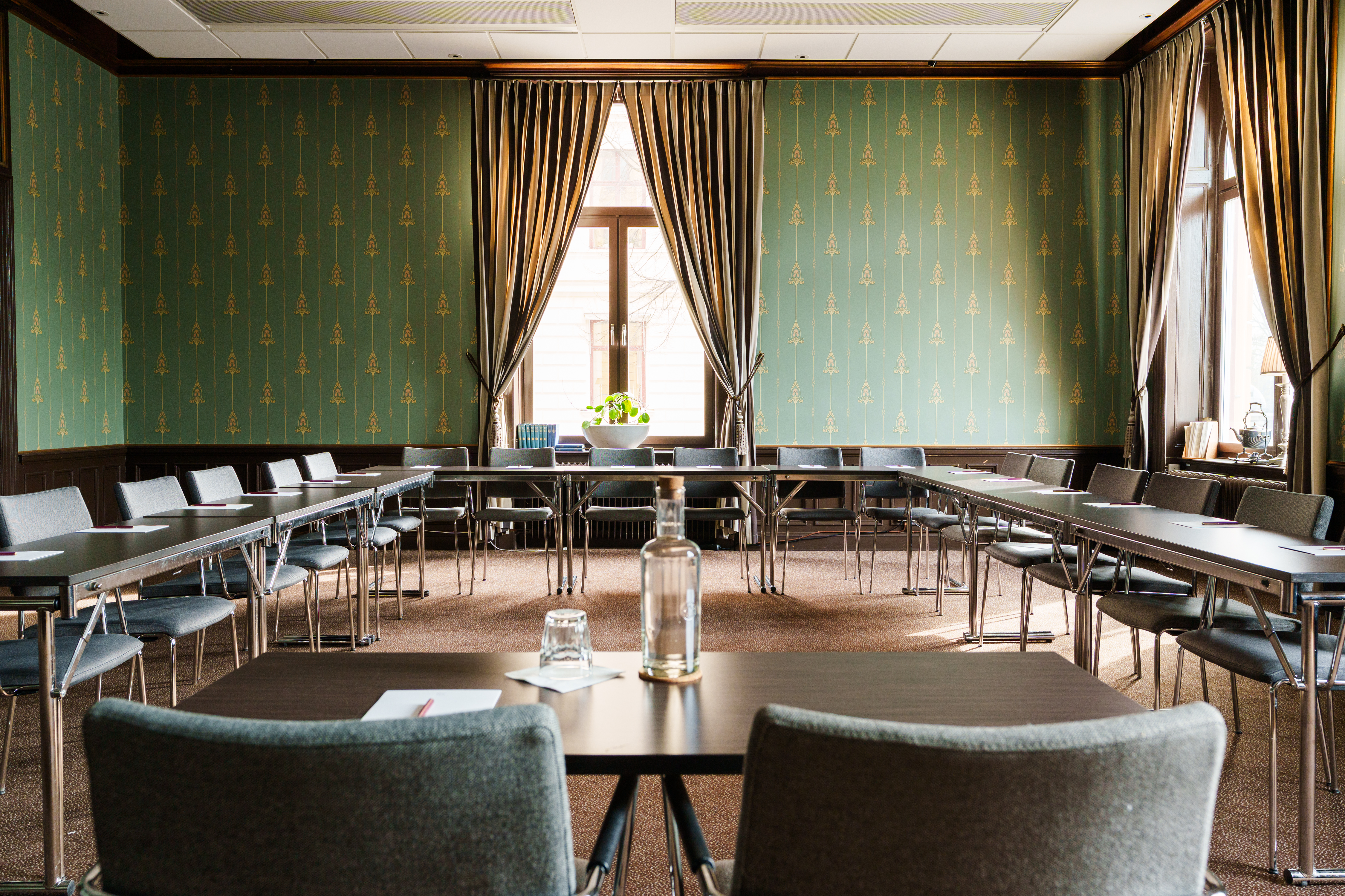 Fin konferenssal med bord, stora dörrar och fönster