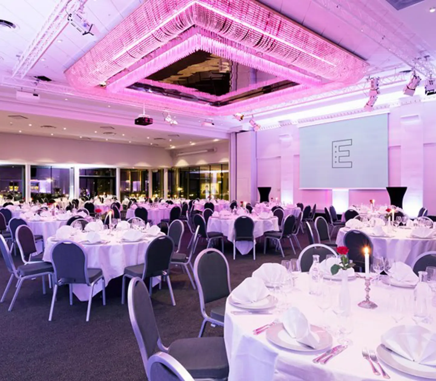 tillställning med runda bord och rosa ljus