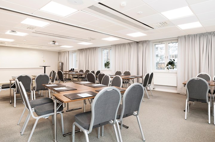 White conference room with round tables and chairs