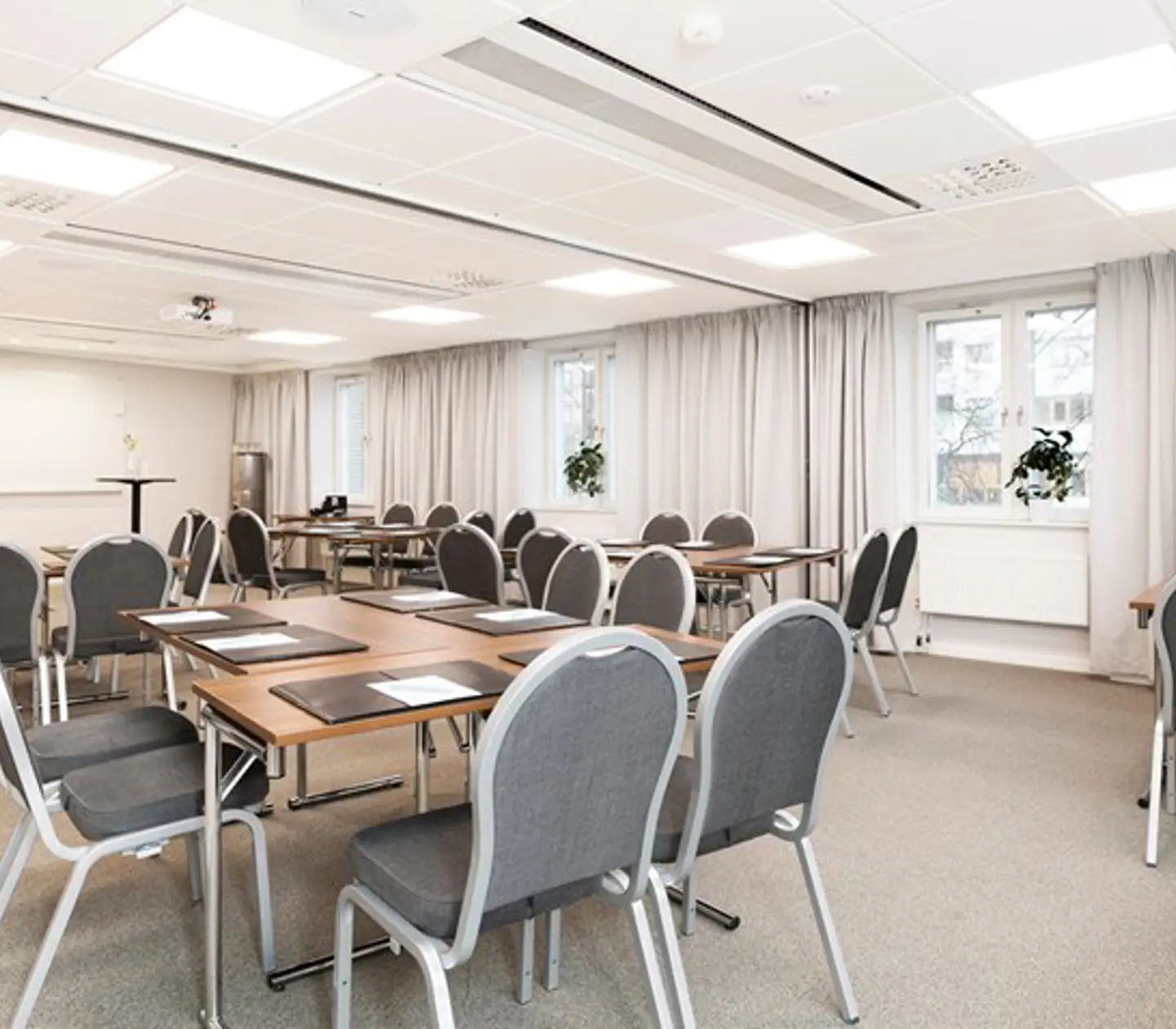 Vitt konferensrum med runda bord och stolar