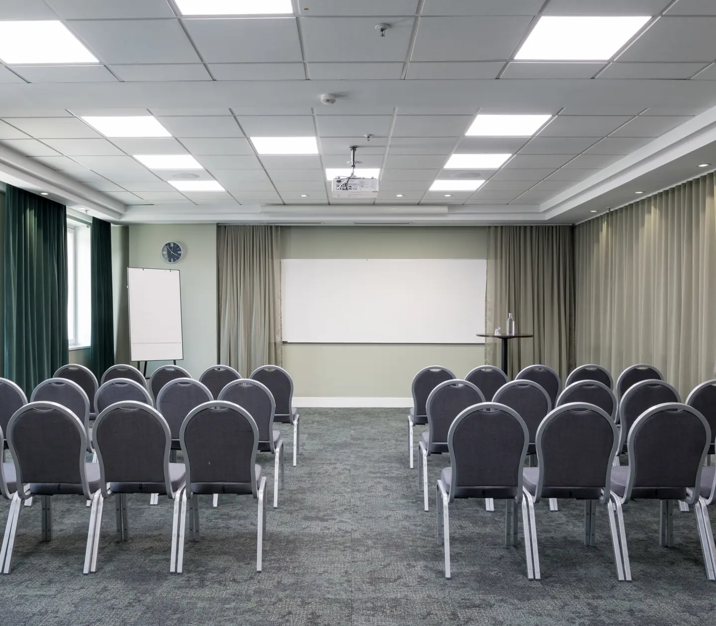 Fint konferensrum med stolar i rader, gardiner och whiteboard