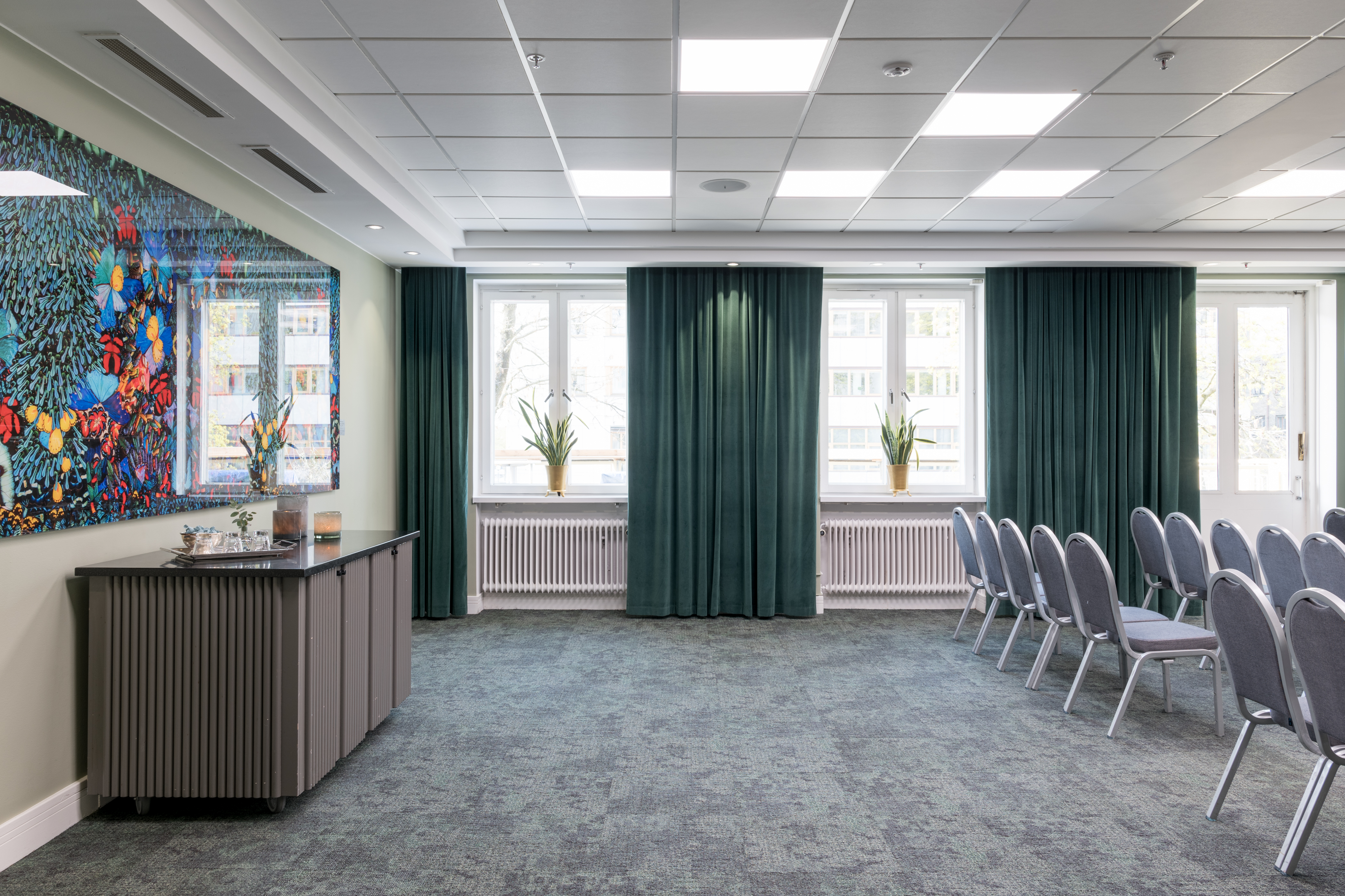 Bright conference room with chairs in rows, windows, and a colorful whiteboard.
