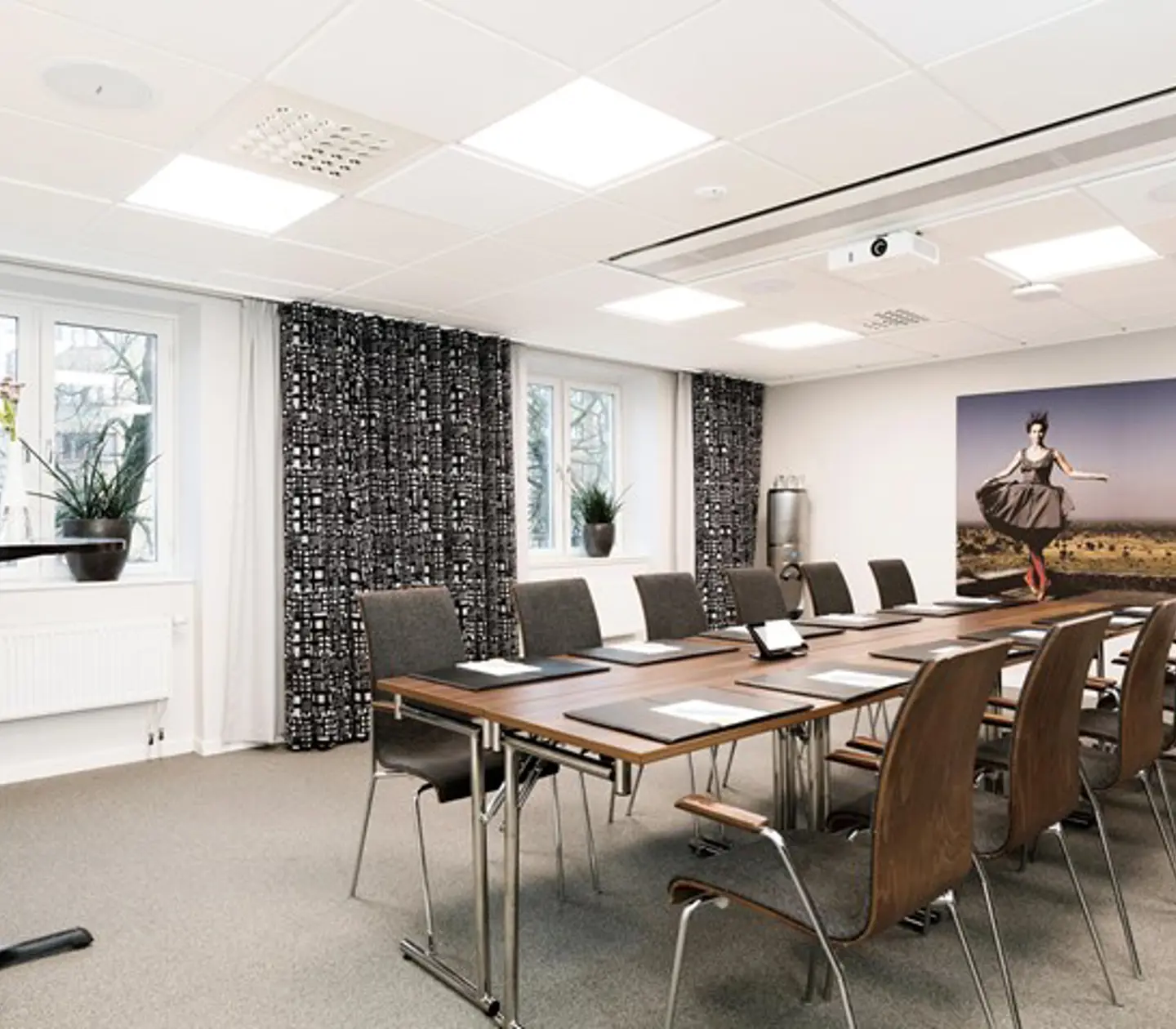 Konferensbord styrelsesittning i konferrensrum med gråa gardiner