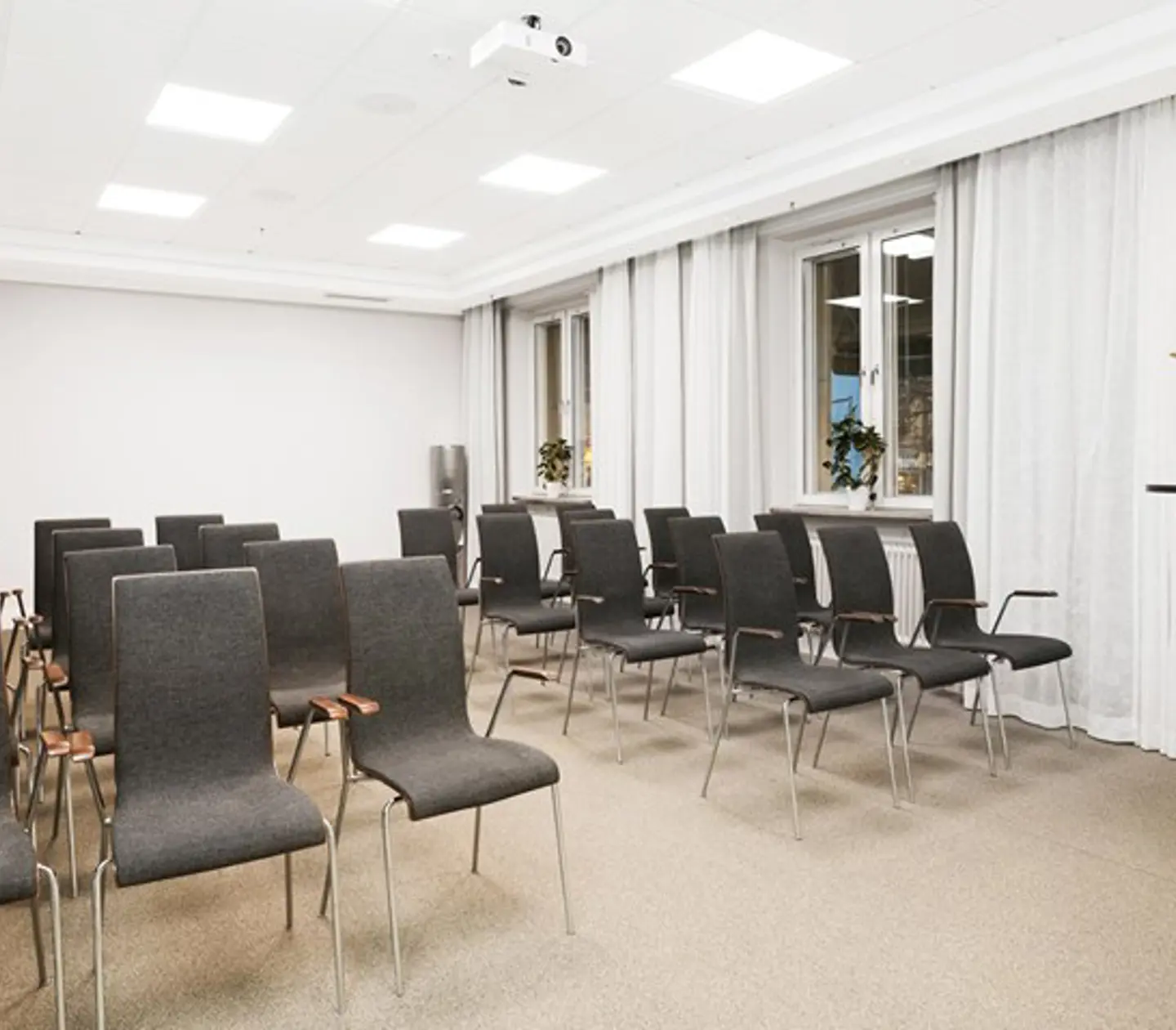Konferensrum med stolar på rad