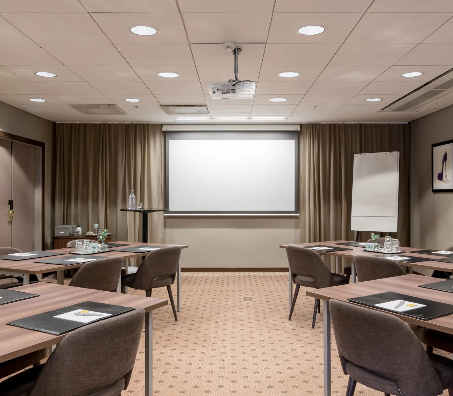 Fint konferensrum med flera bord, stolar och whiteboard