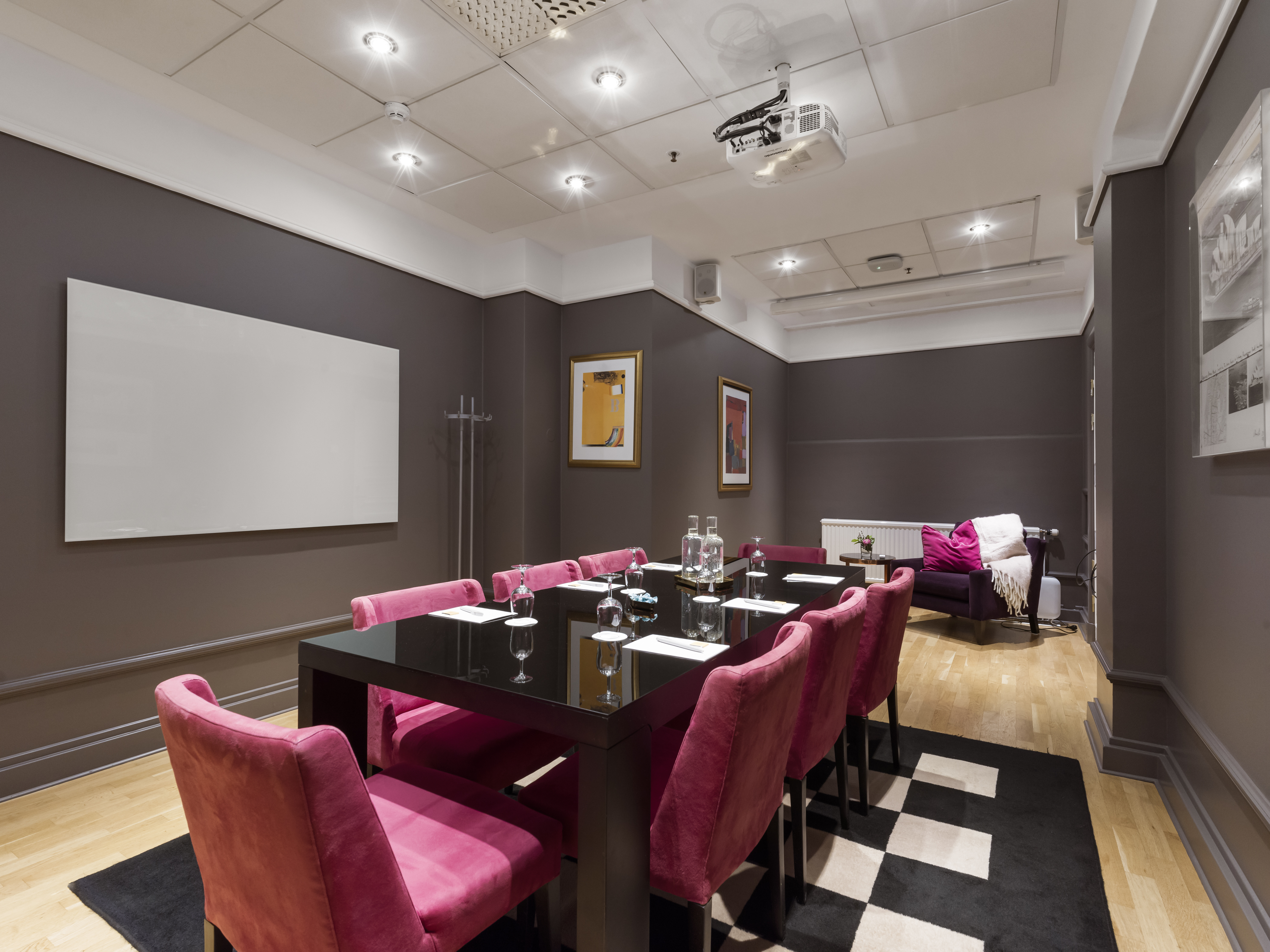 Mindre grupprum med 8 rosa stolar och svart bord