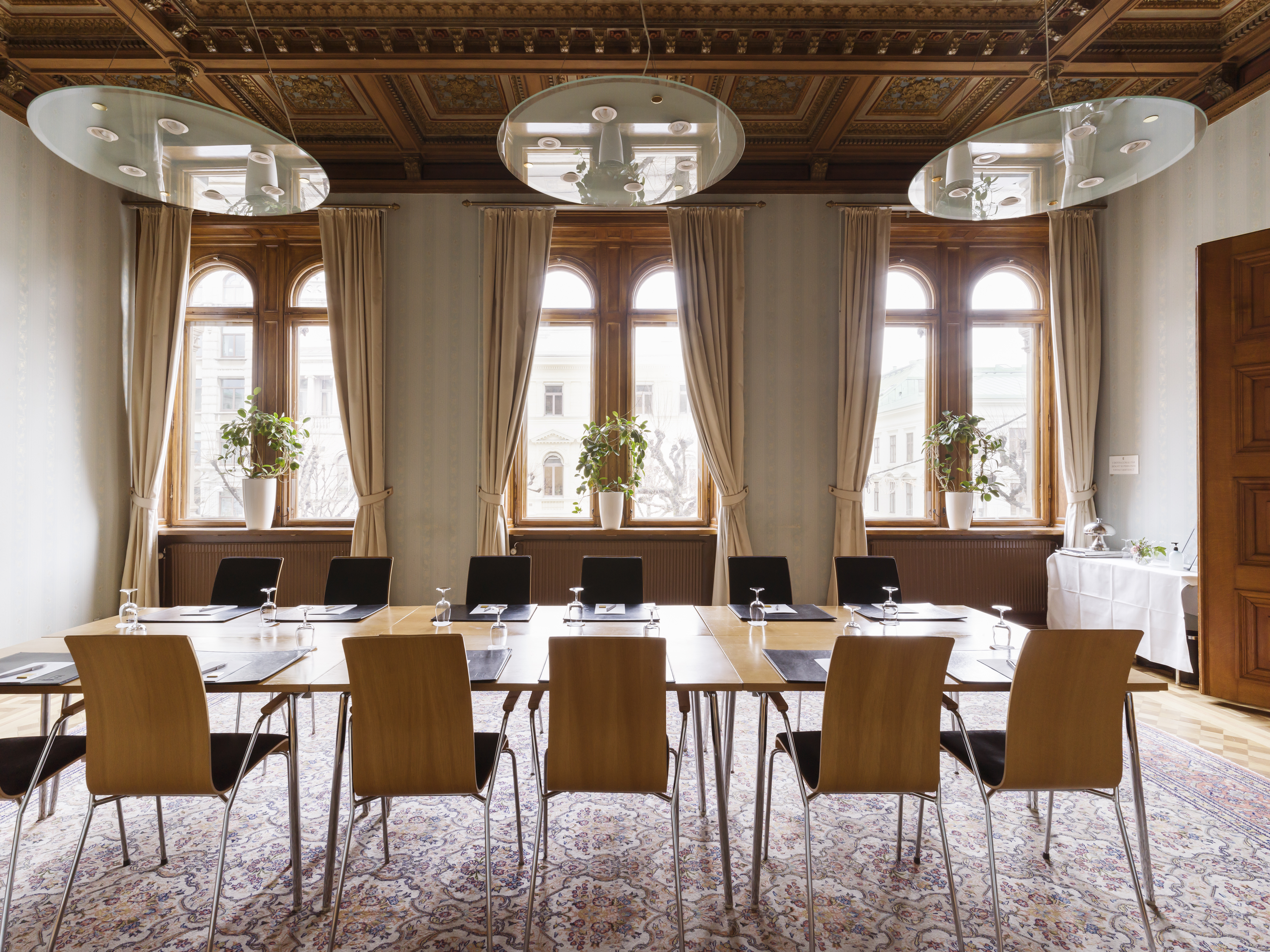 Pampigt konferensrum med dekorationer i taket, stora taklampor och stora fönster