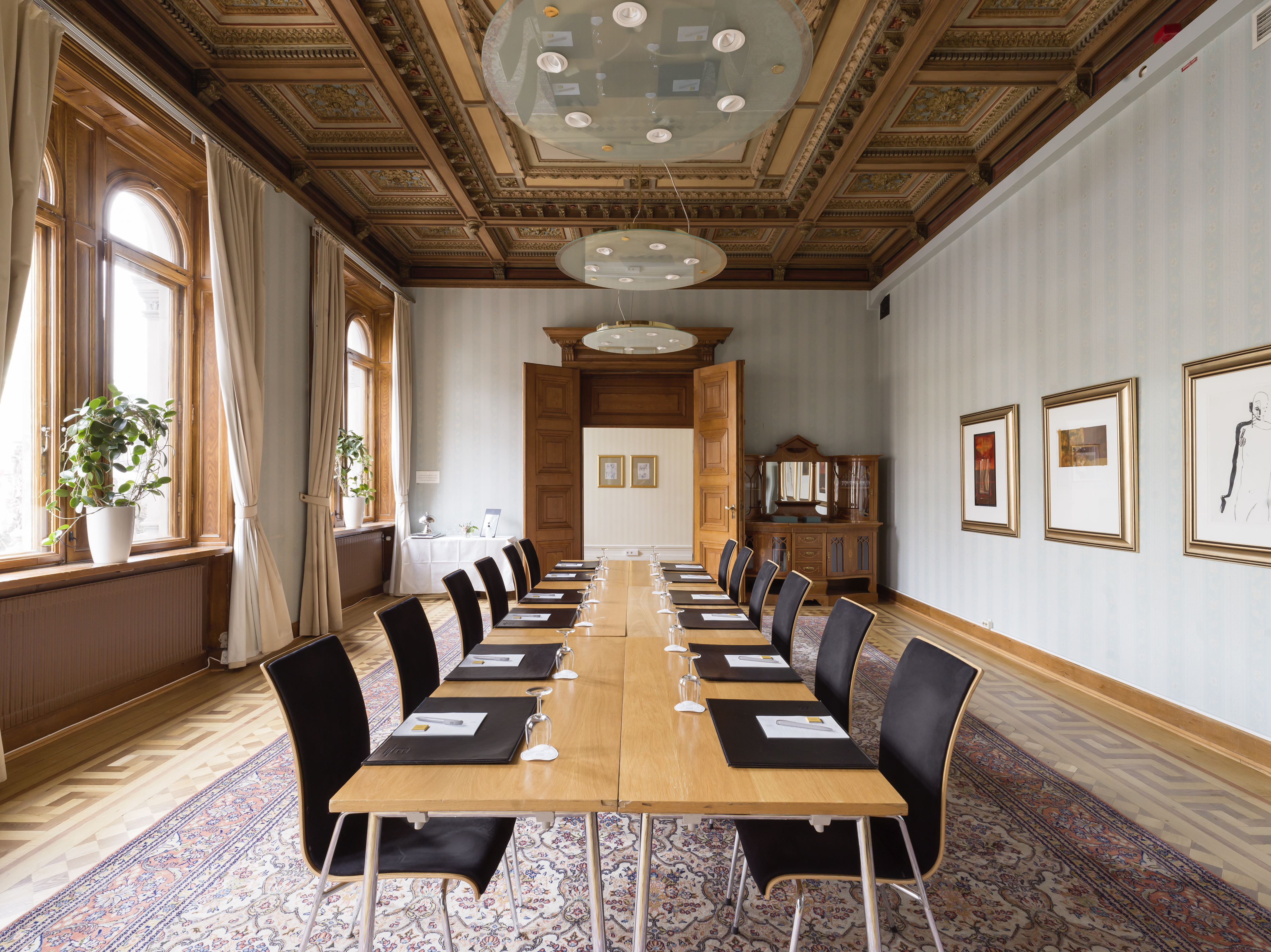 Pampigt konferensrum med dekorationer i taket, stora taklampor och stora fönster