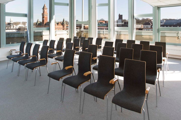 Conference room with lined up black chairs, gray carpet and large windows