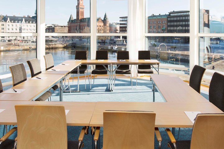 Conference room with U-shaped seating, wooden tables and large windows