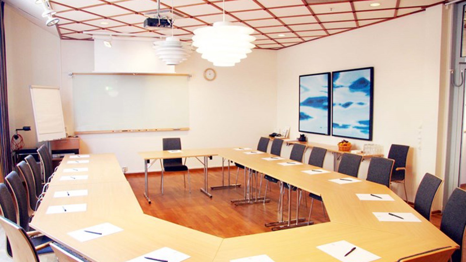 Conference room with u-shaped seating, wooden details and white walls
