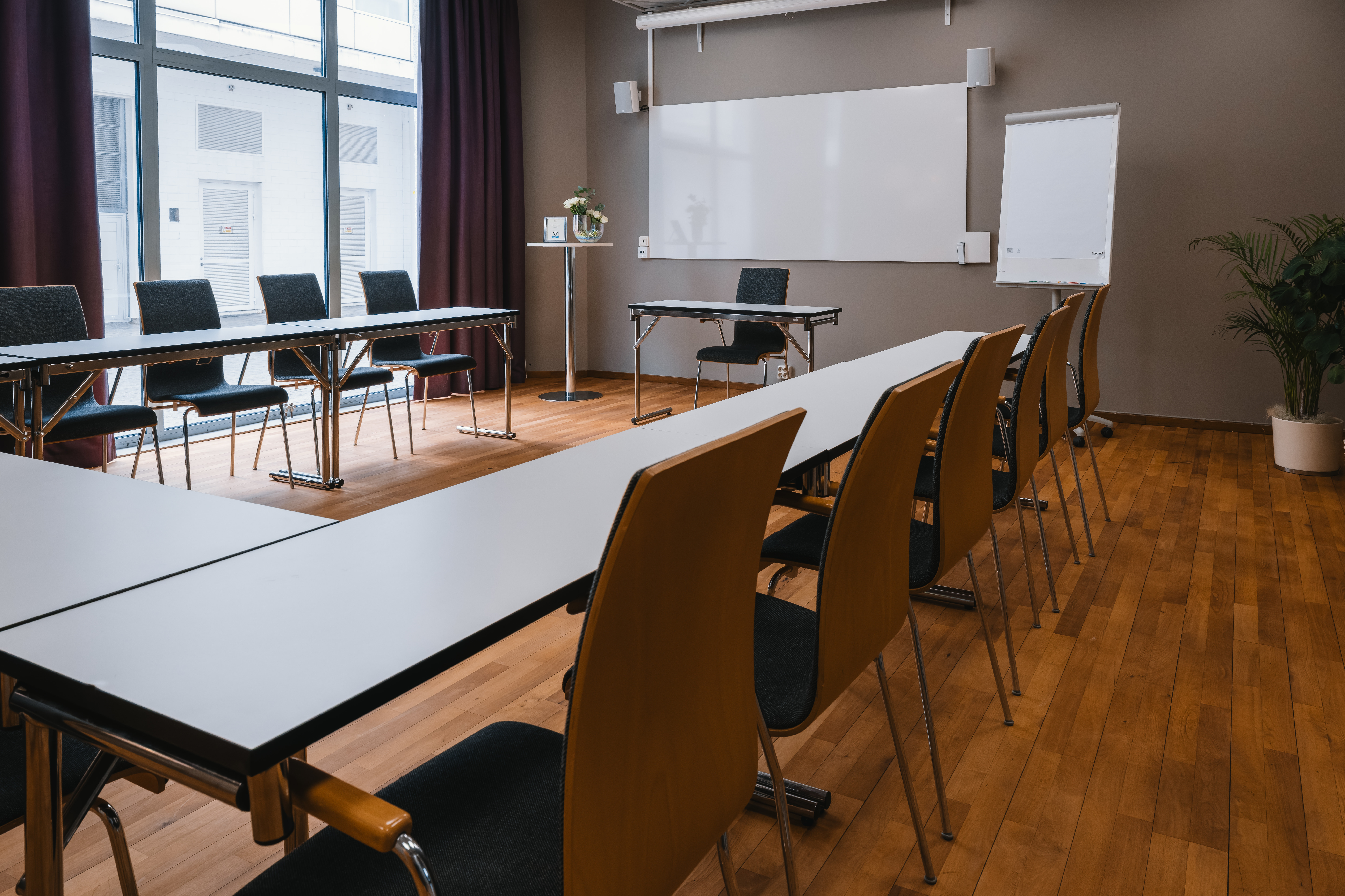 Conference room with u-shaped seating, wooden details and white walls