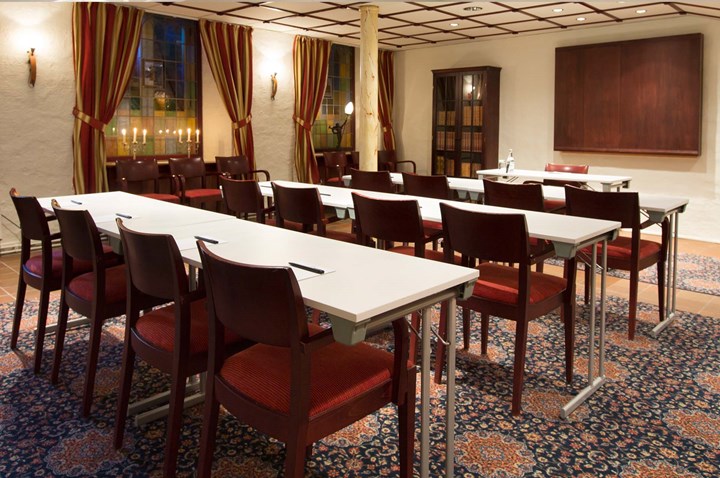Conference room with lined up chairs, patterned carpet and striped curtains