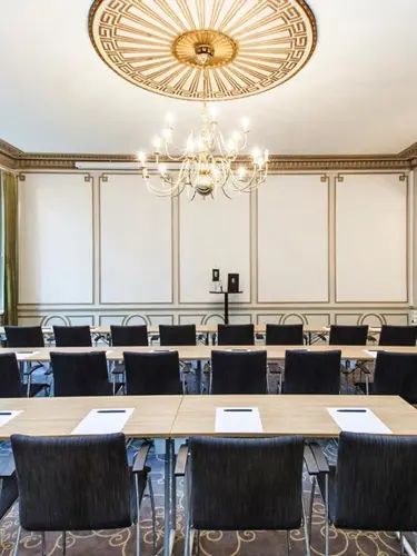 Konferensrum med bord, stolar och stora fönster