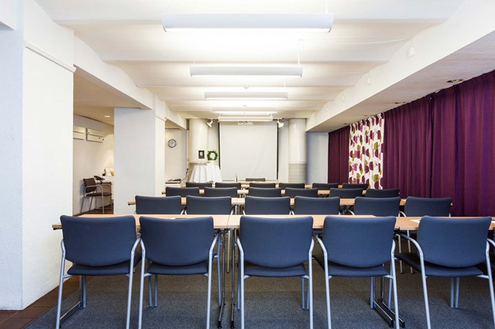 Conference room with lined up blue chairs and purple drapery