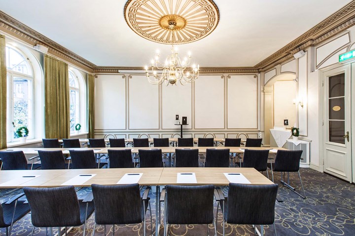 Conference room with long table, blue carpet and gold details