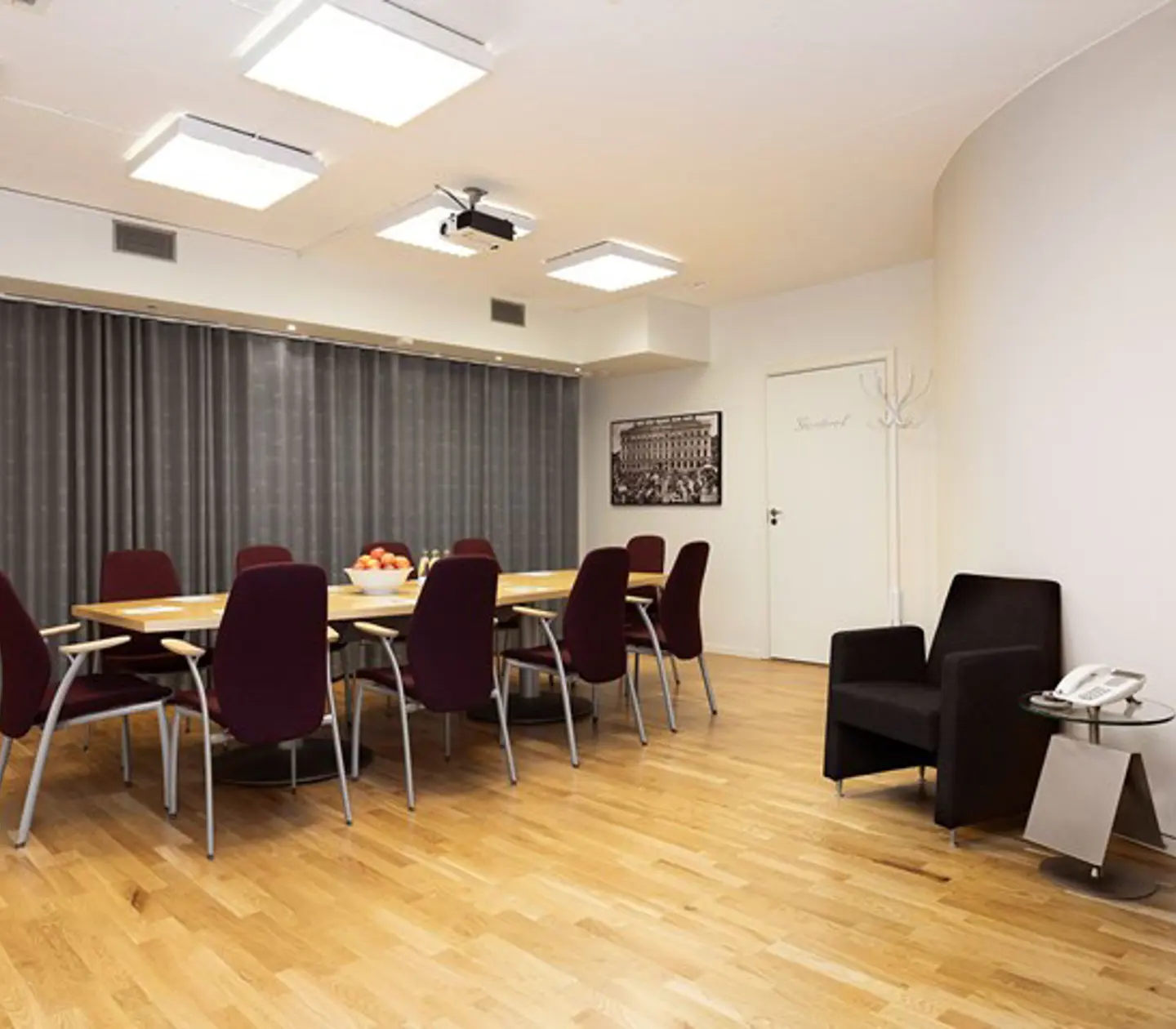 Group room with board seating, wooden floor and white walls